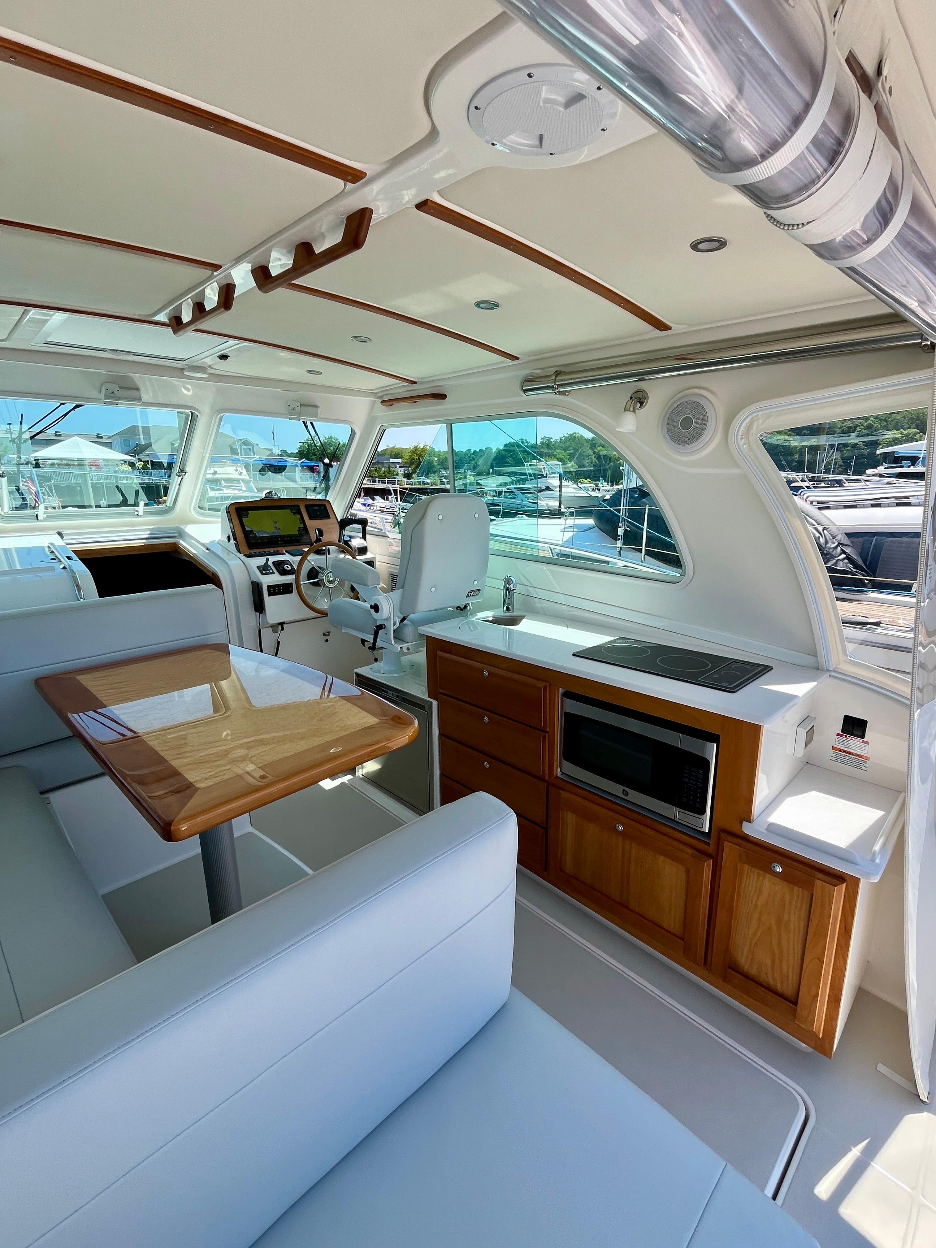 Interior of 2023 Back Cove 34O yacht with modern seating and kitchen amenities.