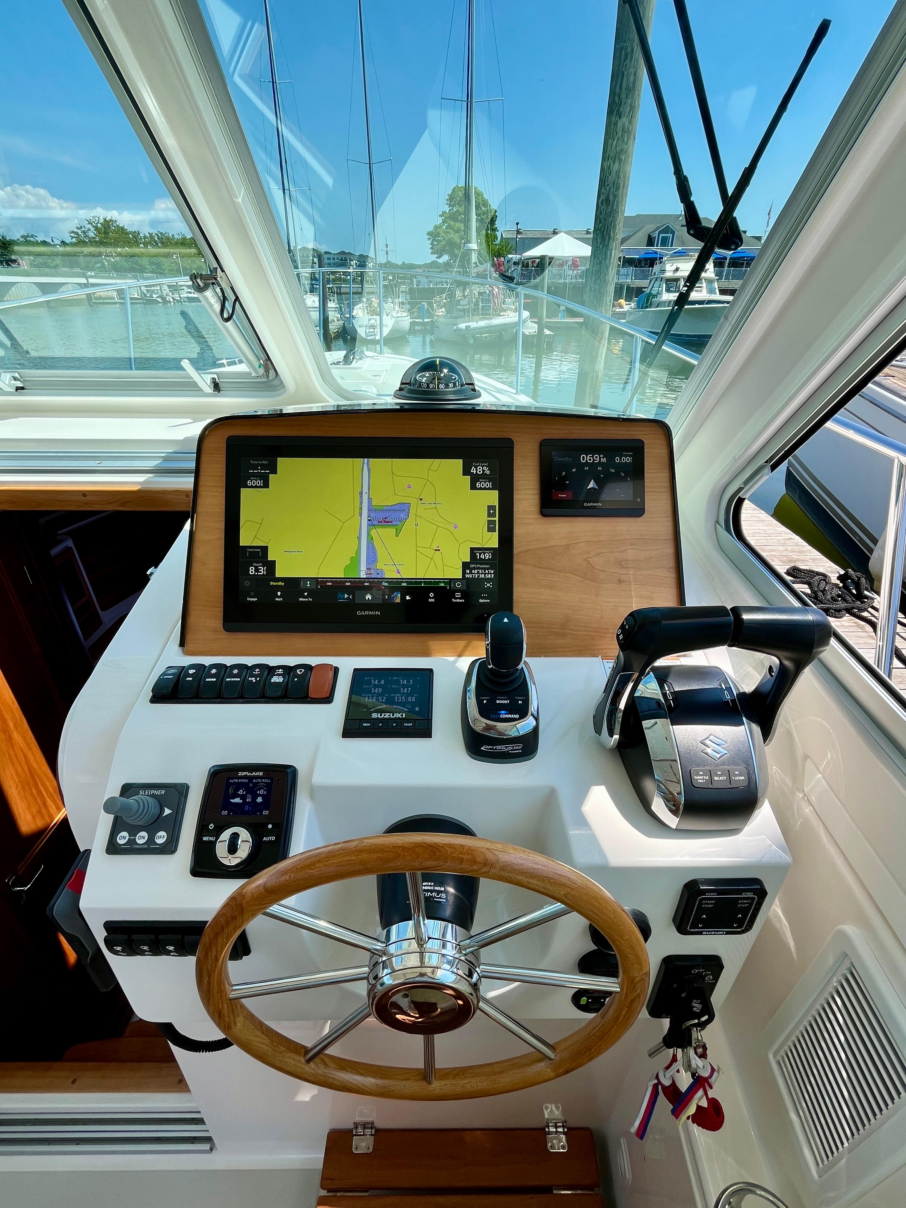 2023 Back Cove 34O helm with navigation display and controls, docked at marina.