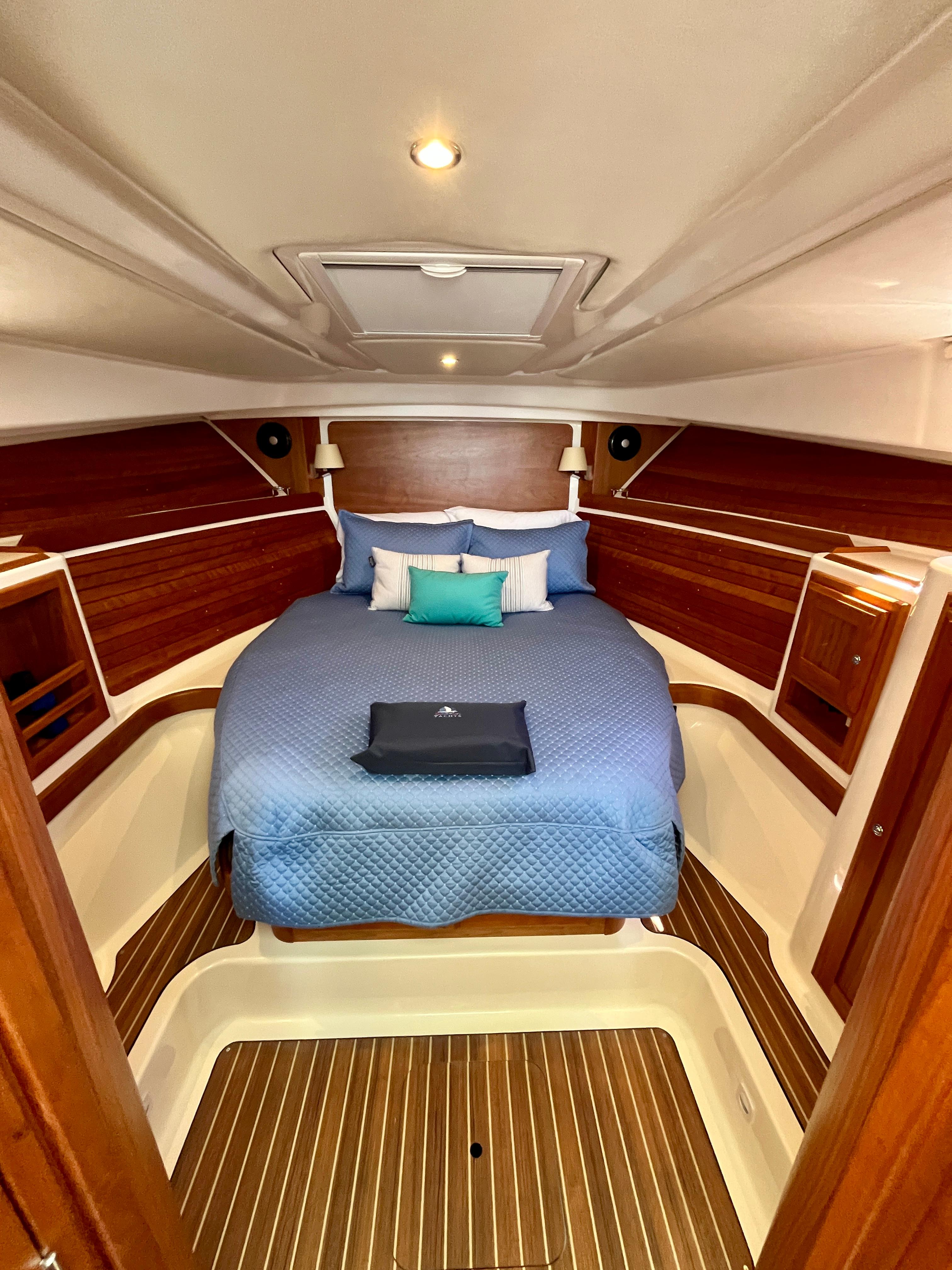 Luxurious cabin interior of 2023 Back Cove 34O with elegant wood finish and cozy bedding.