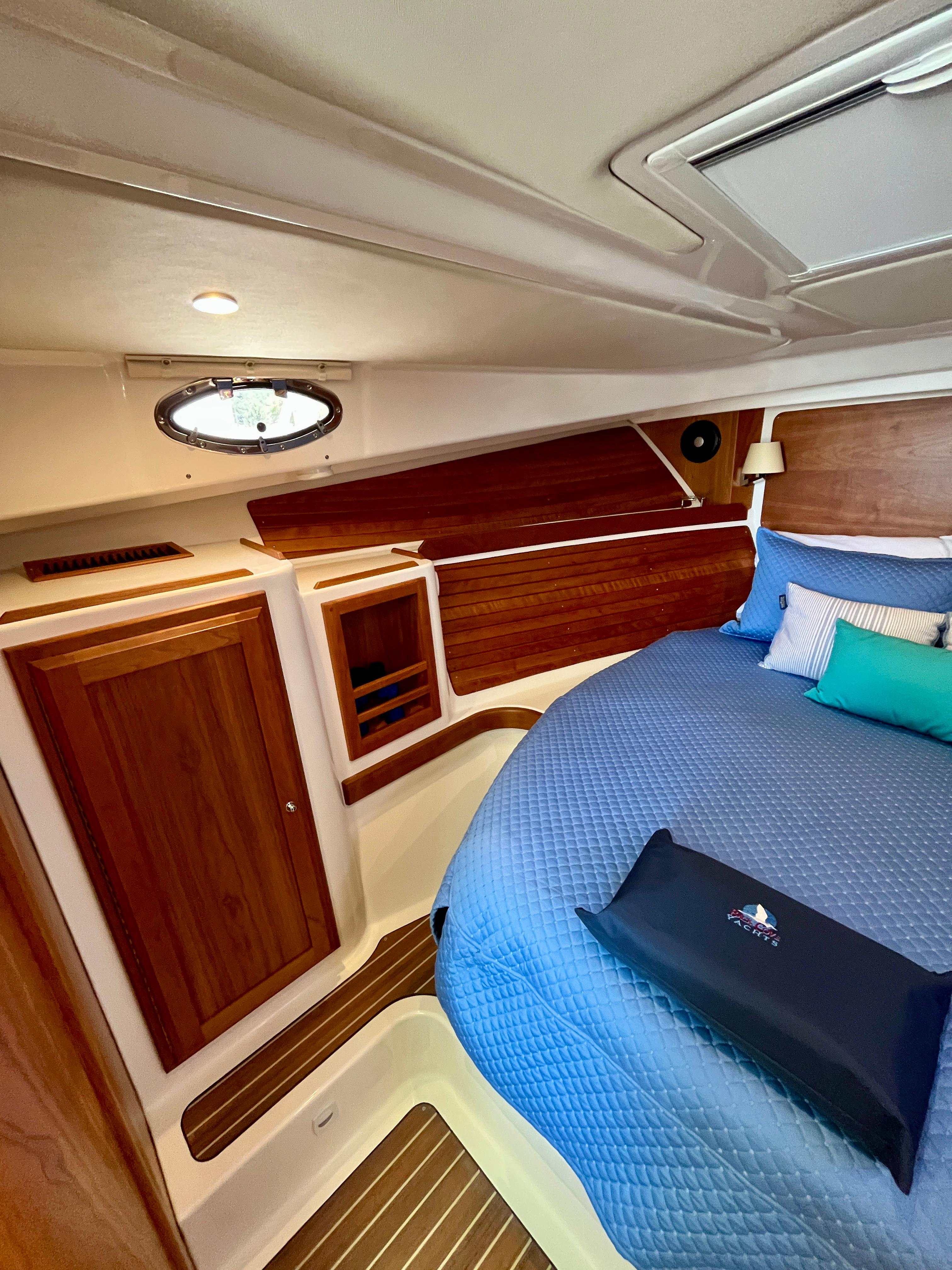 Luxurious cabin interior of 2023 Back Cove 34O with wood accents and cozy bedding.