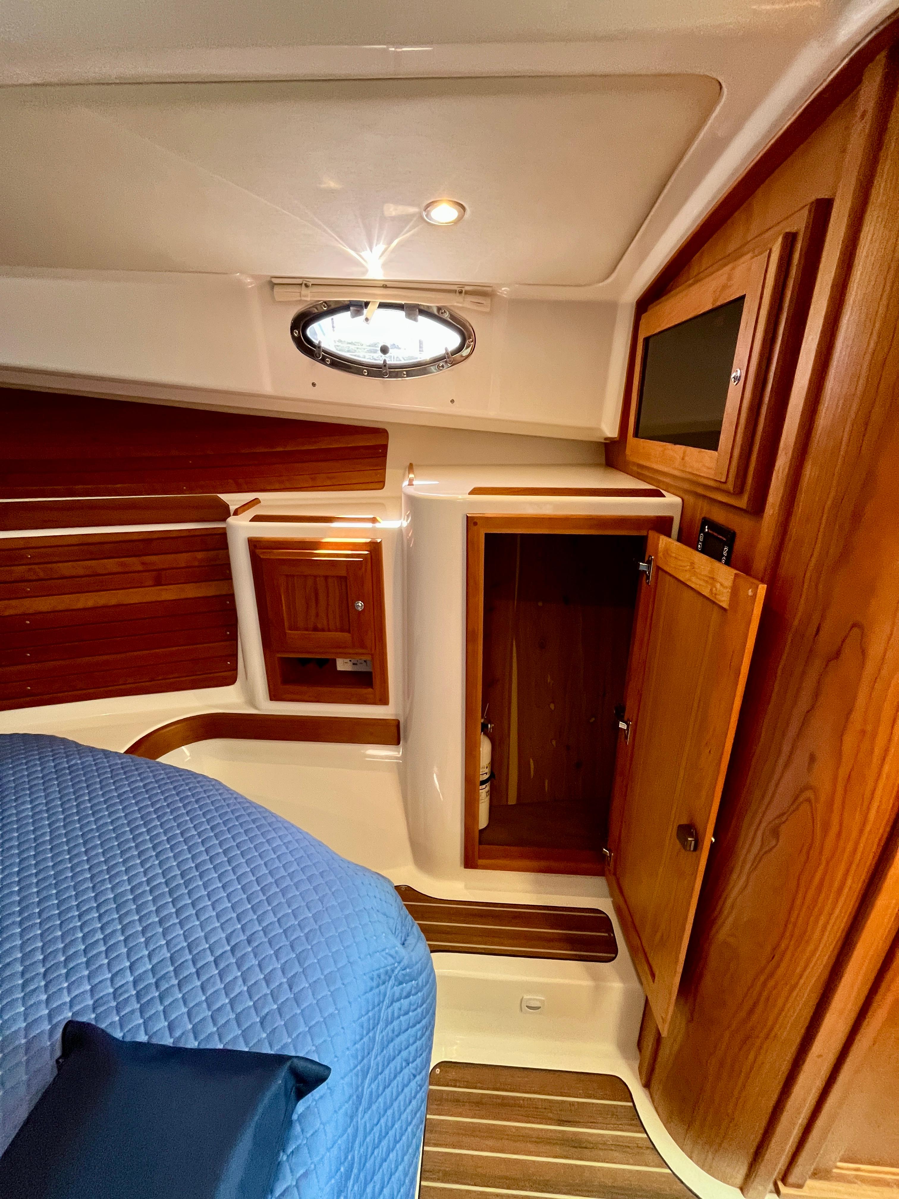 2023 Back Cove 34O cabin interior with wood finish and blue bedding.