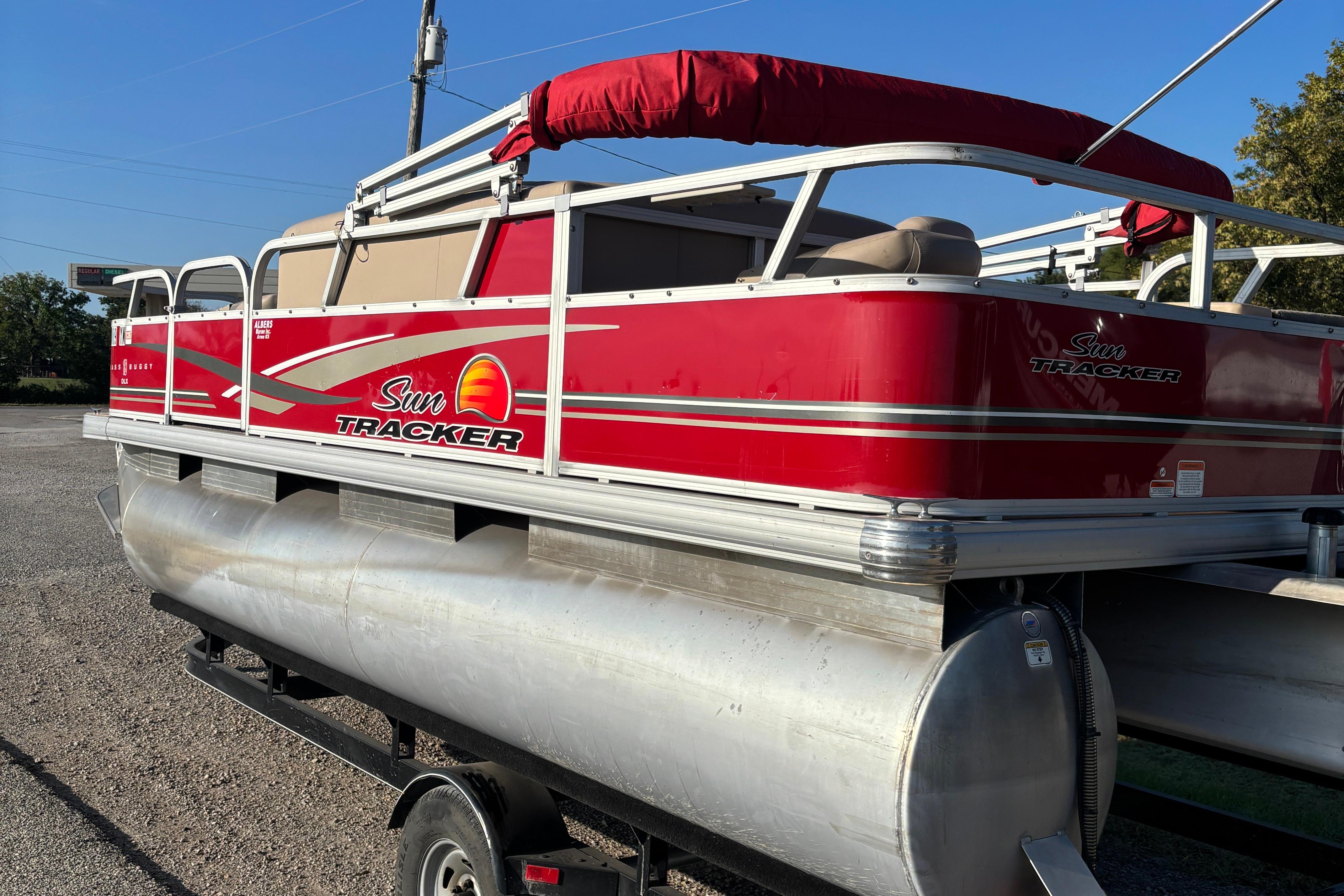 2014 Sun Tracker Bass Buggy 18 DLX pontoon boat with red exterior on trailer.