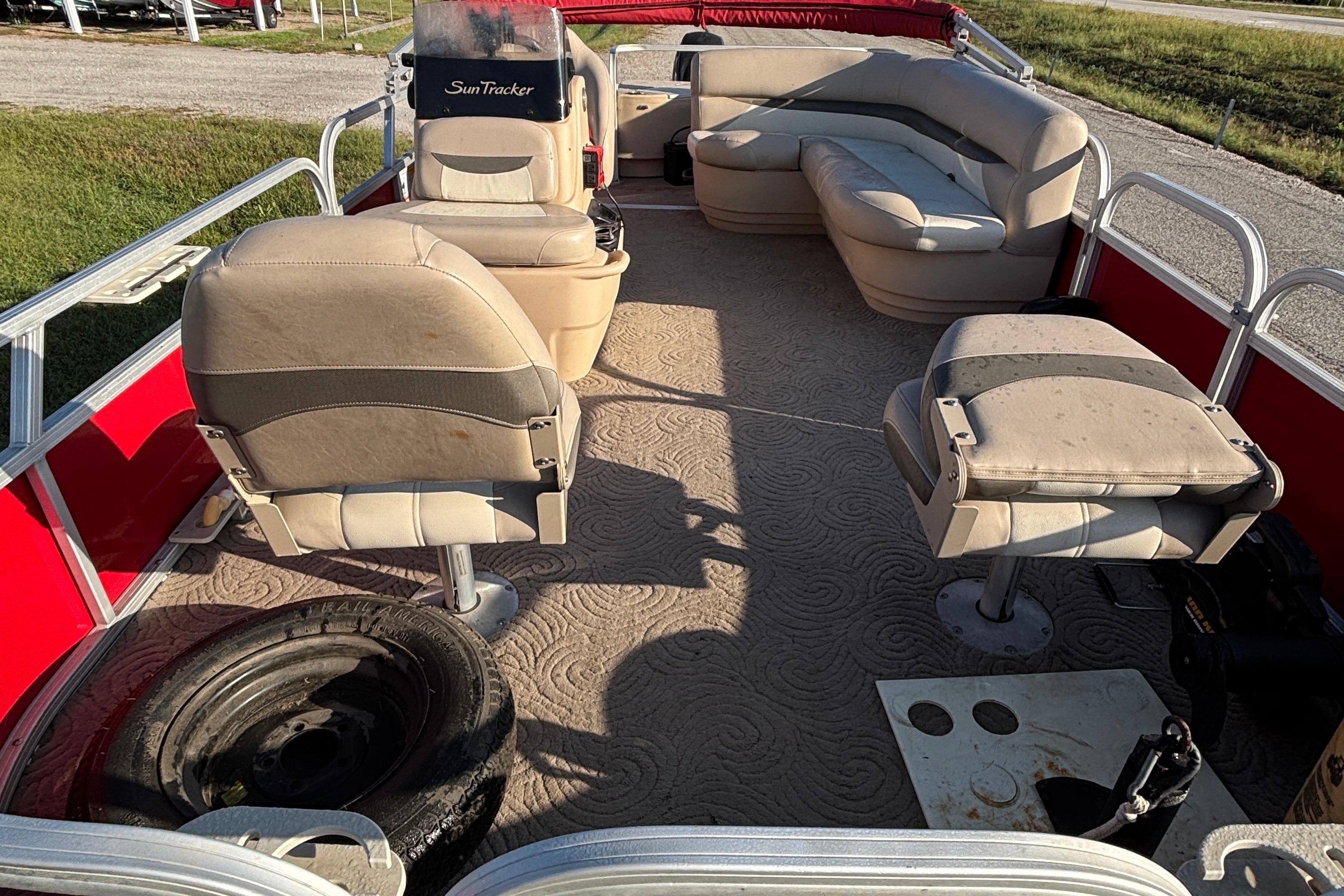 2014 Sun Tracker Bass Buggy 18 DLX pontoon boat interior with seating and a spare tire.