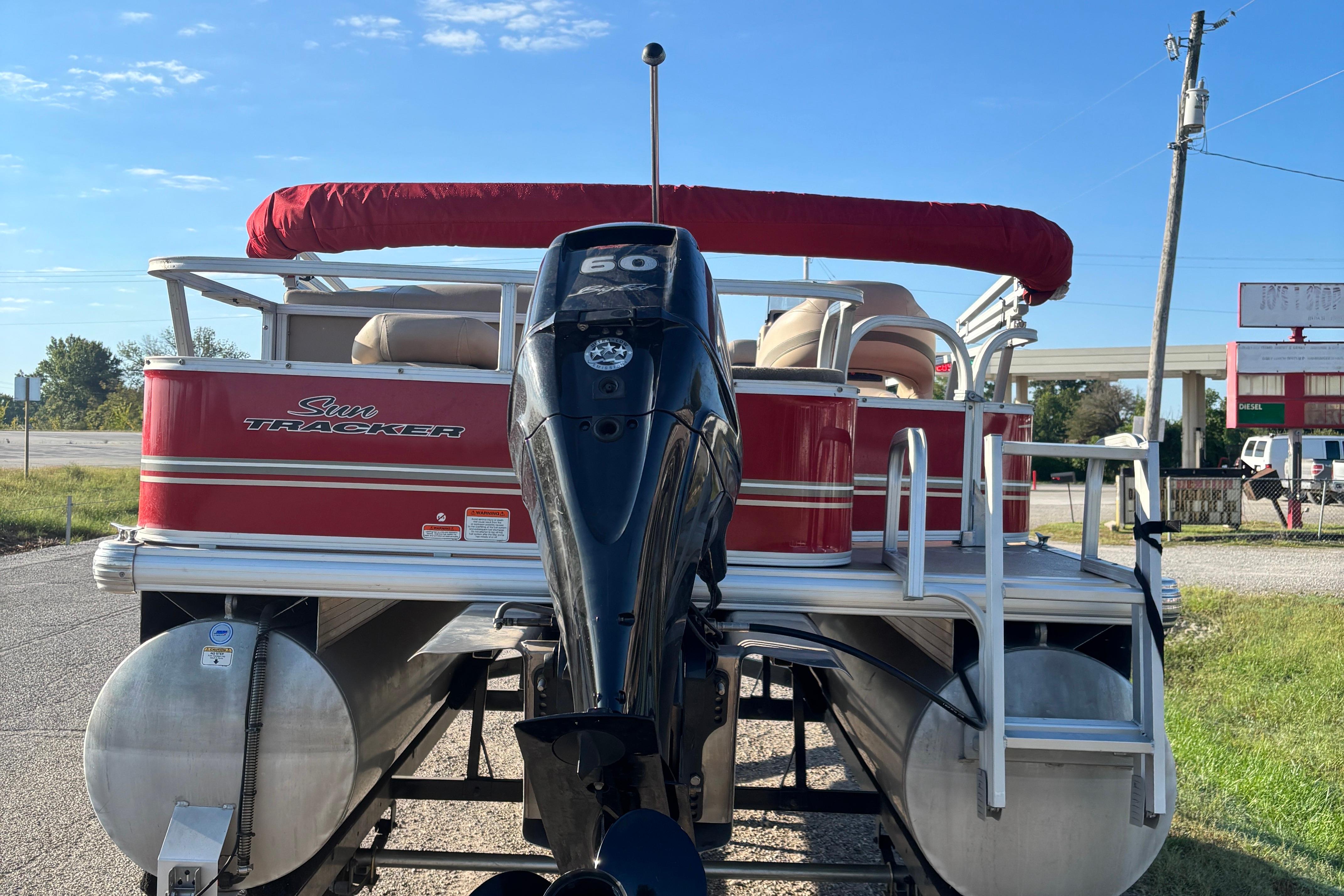 2014 Sun Tracker Bass Buggy 18 DLX pontoon boat with red canopy and outboard motor.