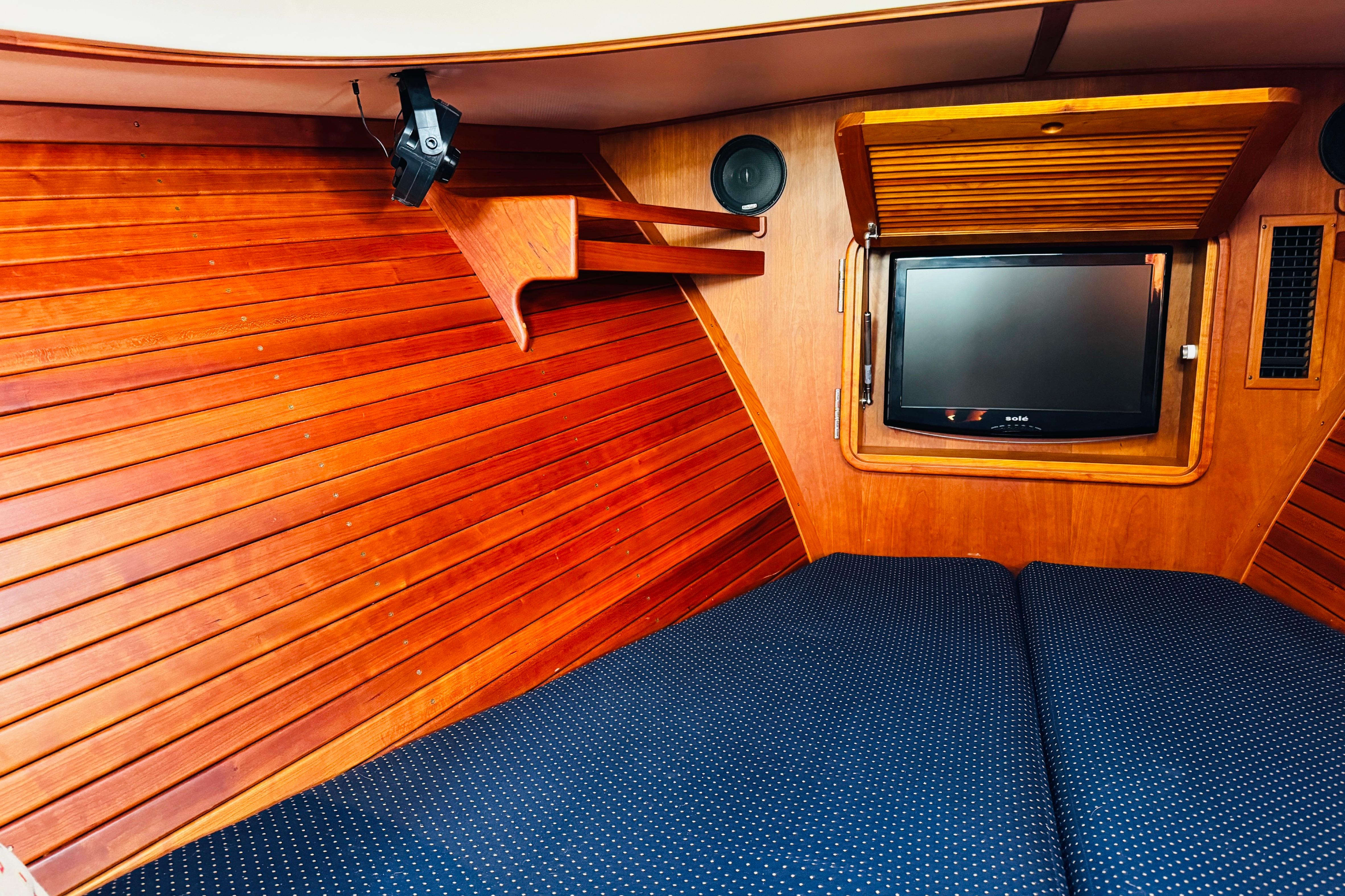 Interior of 2012 Hinckley Picnic Boat MKIII with wood paneling and TV.