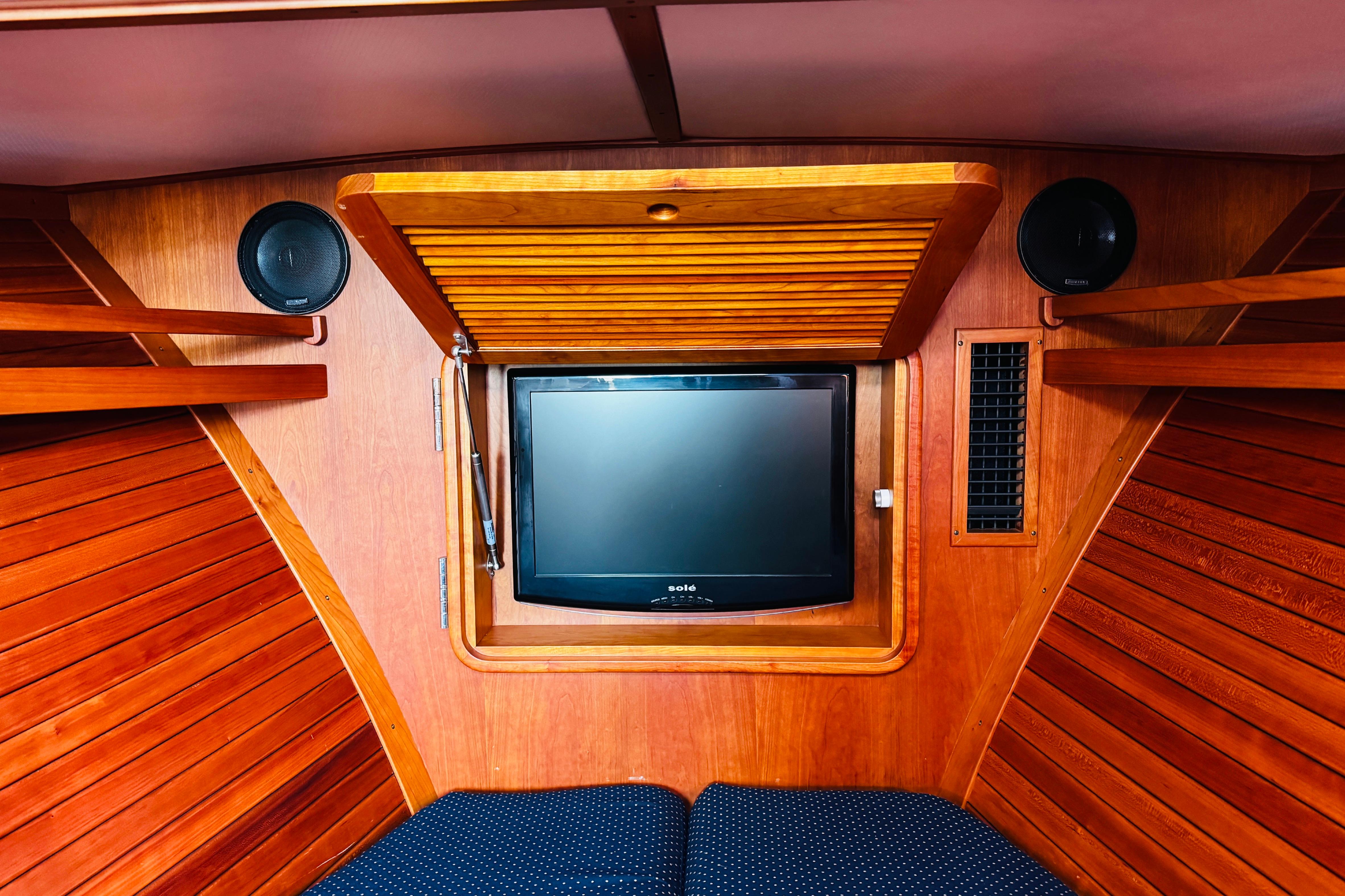 Interior of 2012 Hinckley Picnic Boat MKIII with wooden paneling and built-in TV.