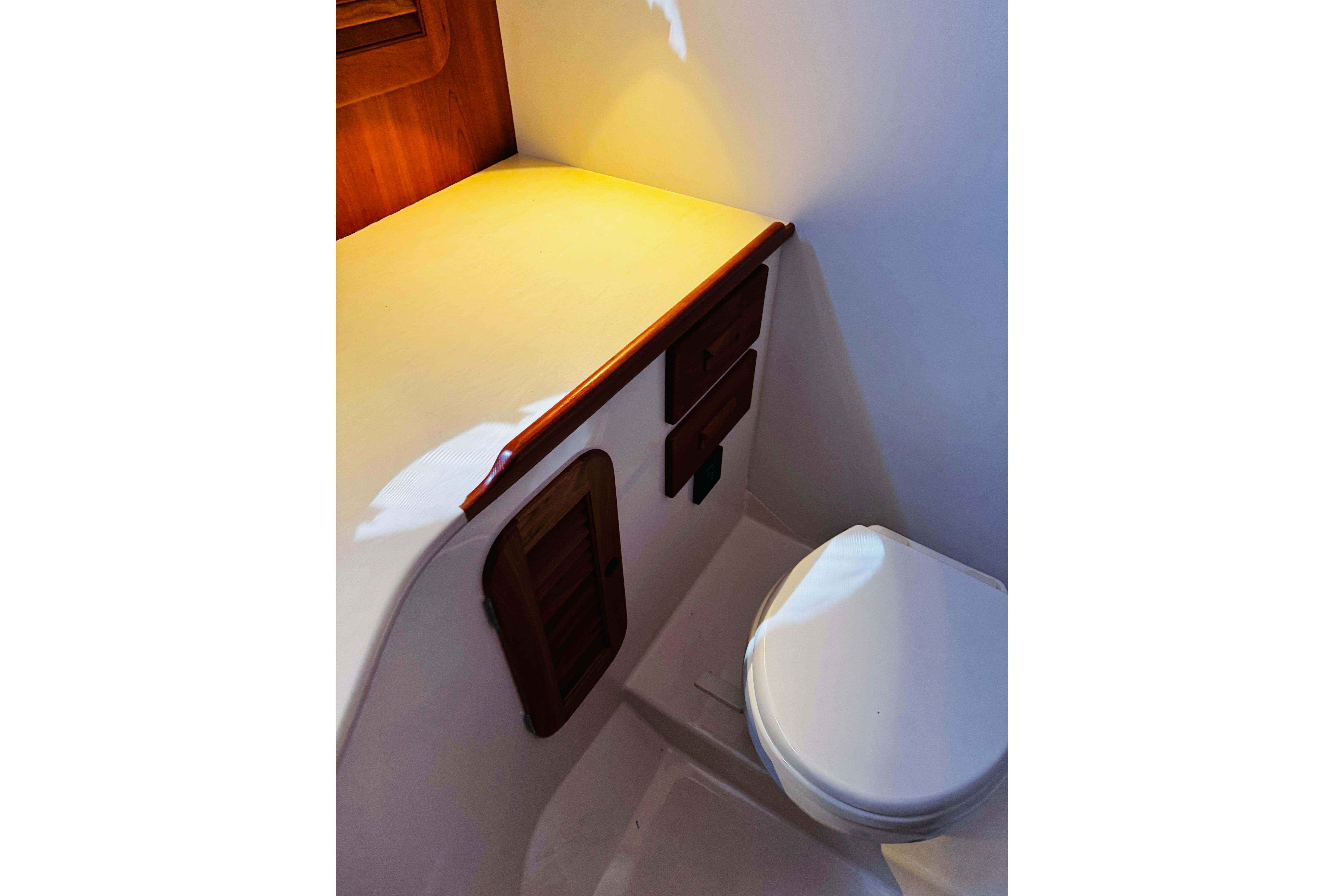 2012 Hinckley Picnic Boat MKIII interior with compact bathroom and wooden cabinetry.