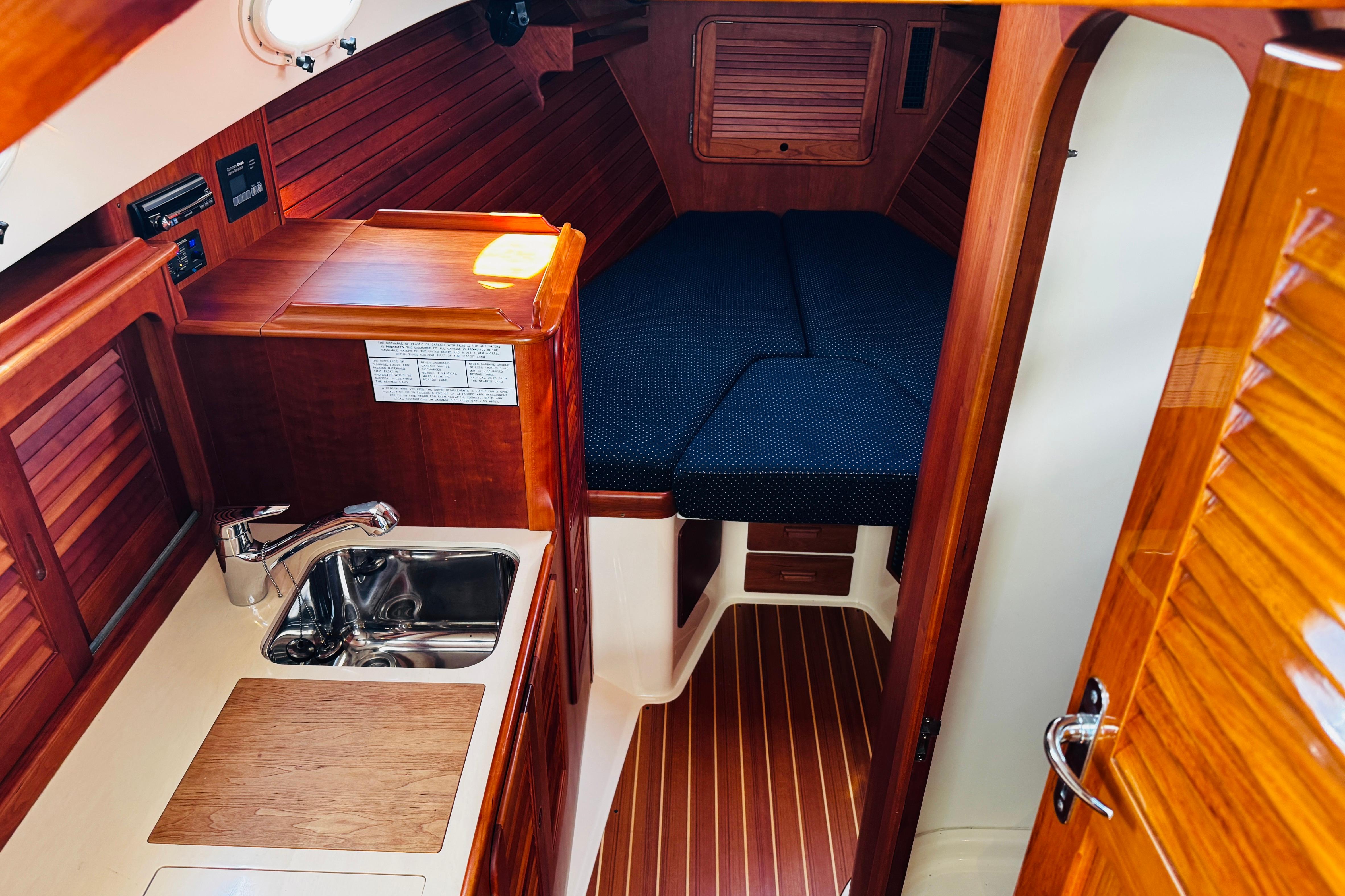 Interior of 2012 Hinckley Picnic Boat MKIII with wood finish and compact kitchenette.