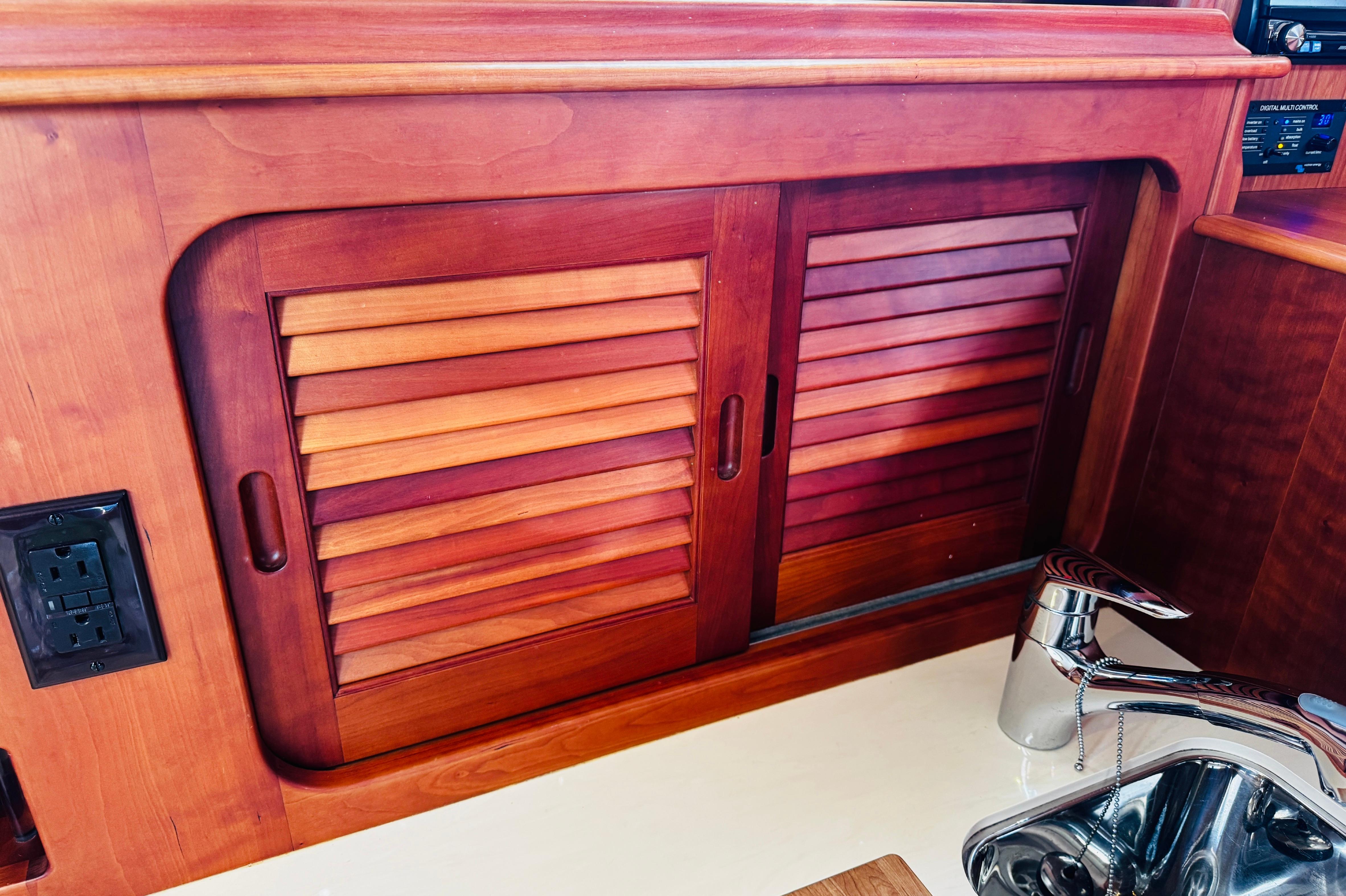 Hinckley Picnic Boat MKIII 2012 interior with wooden cabinet and stainless steel sink.