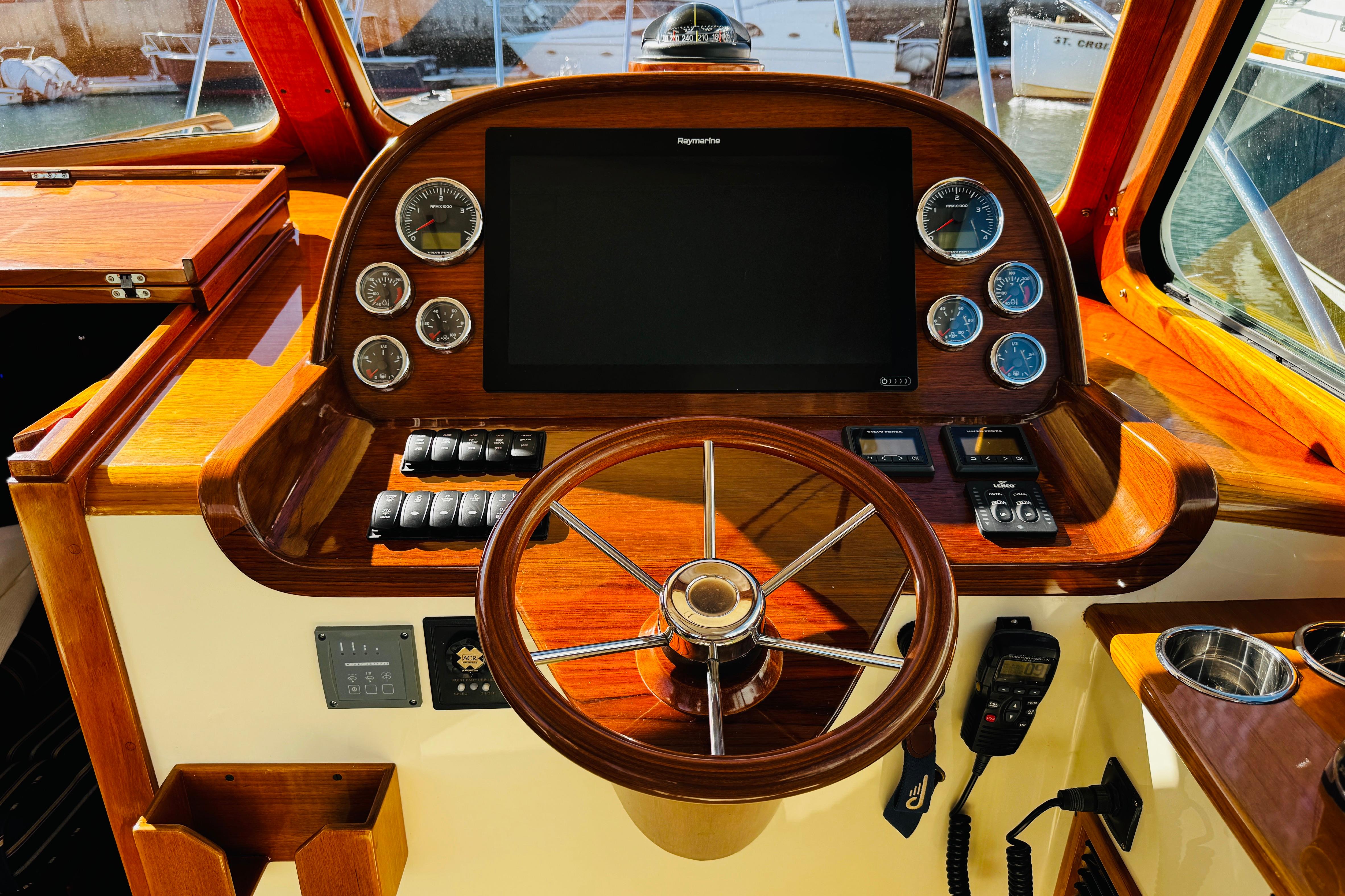 2012 Hinckley Picnic Boat MKIII helm with wooden steering wheel and modern navigation instruments.