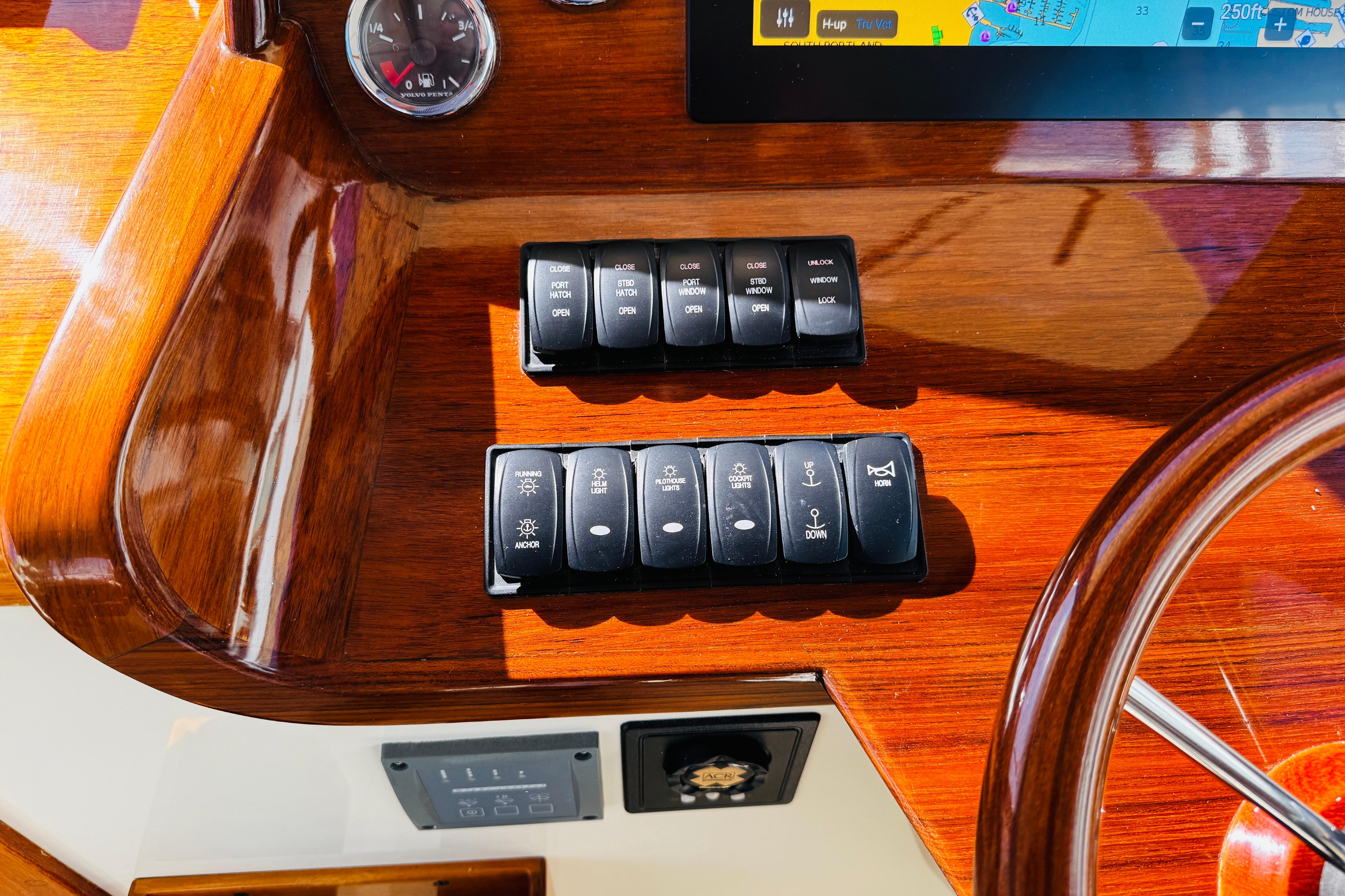 Control panel of a 2012 Hinckley Picnic Boat MKIII with switches and navigation display.