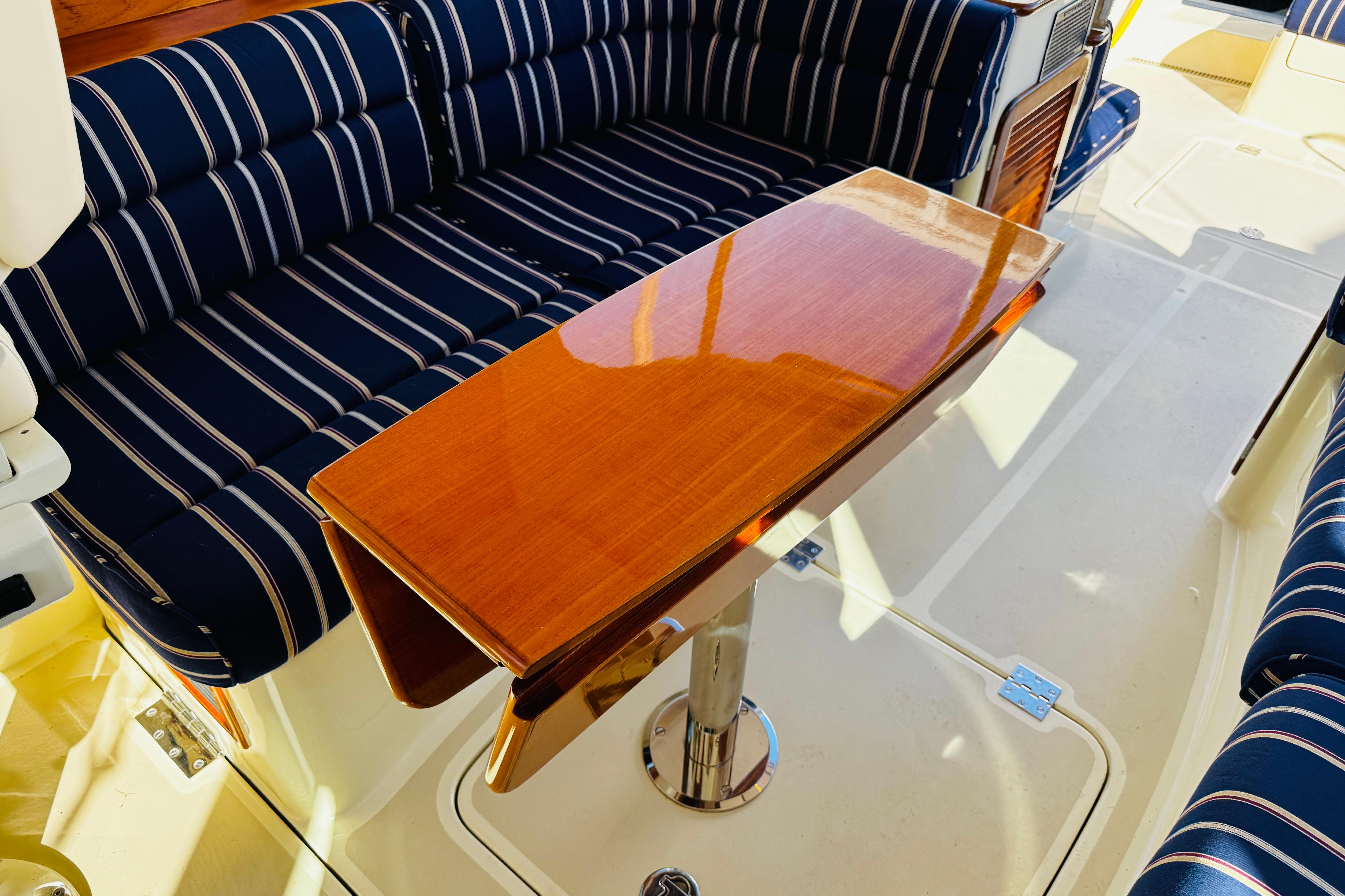 Hinckley Picnic Boat MKIII 2012 interior with striped seating and polished wooden table.