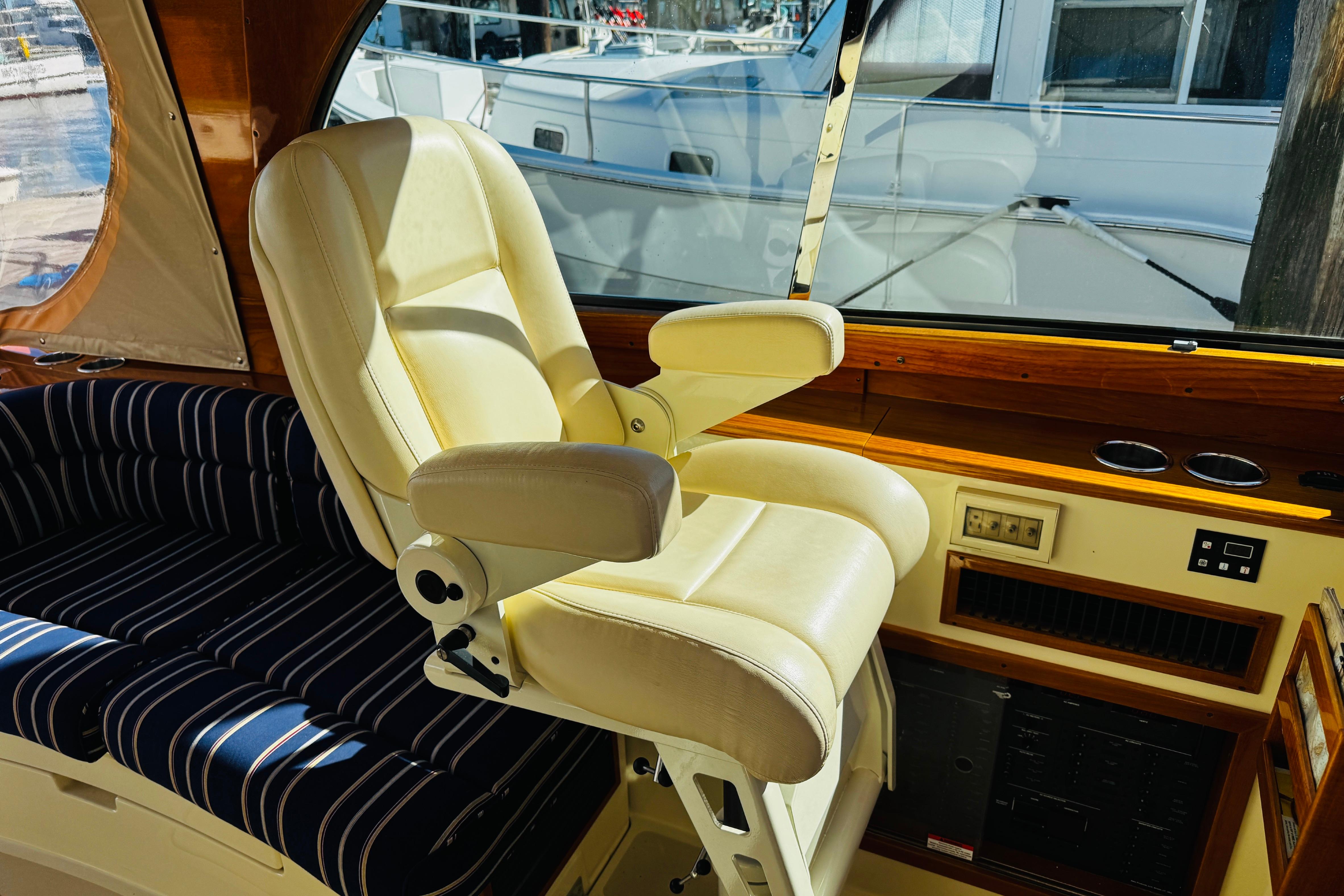 Captainu0027s chair and interior of 2012 Hinckley Picnic Boat MKIII, featuring elegant design and wood accents.