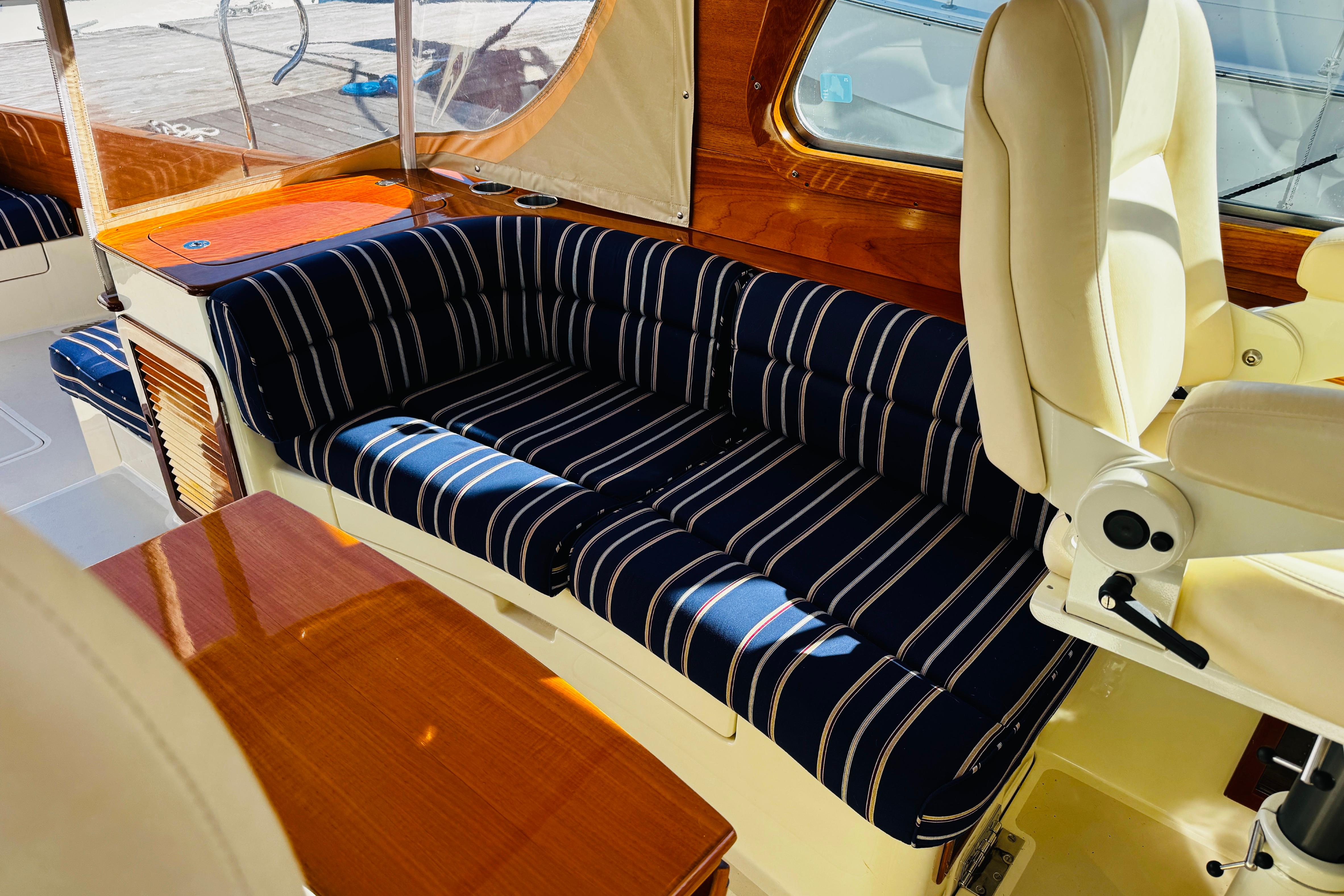 Luxurious interior of 2012 Hinckley Picnic Boat MKIII with striped seating and wooden accents.