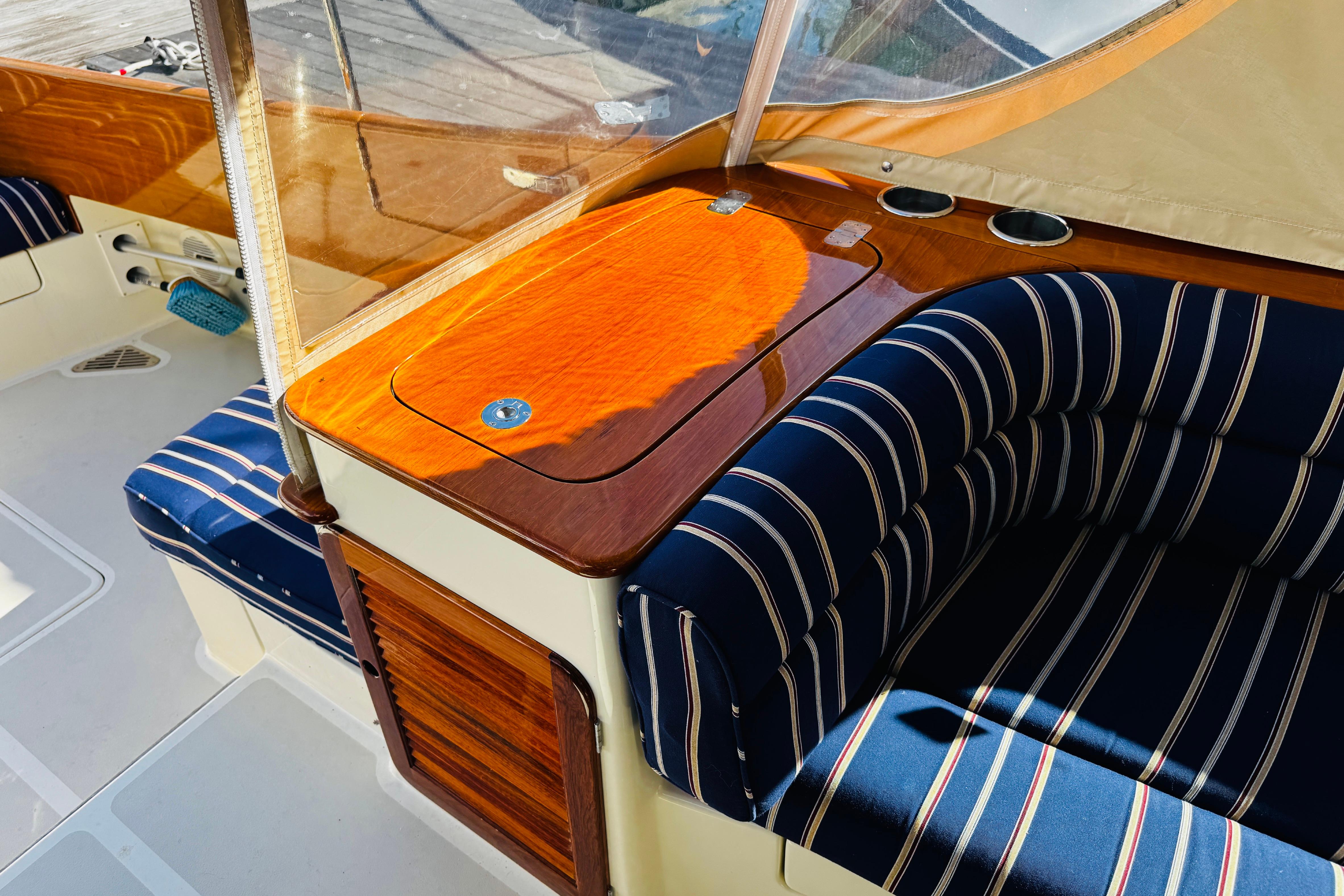 Interior of 2012 Hinckley Picnic Boat MKIII with striped seating and wooden accents.