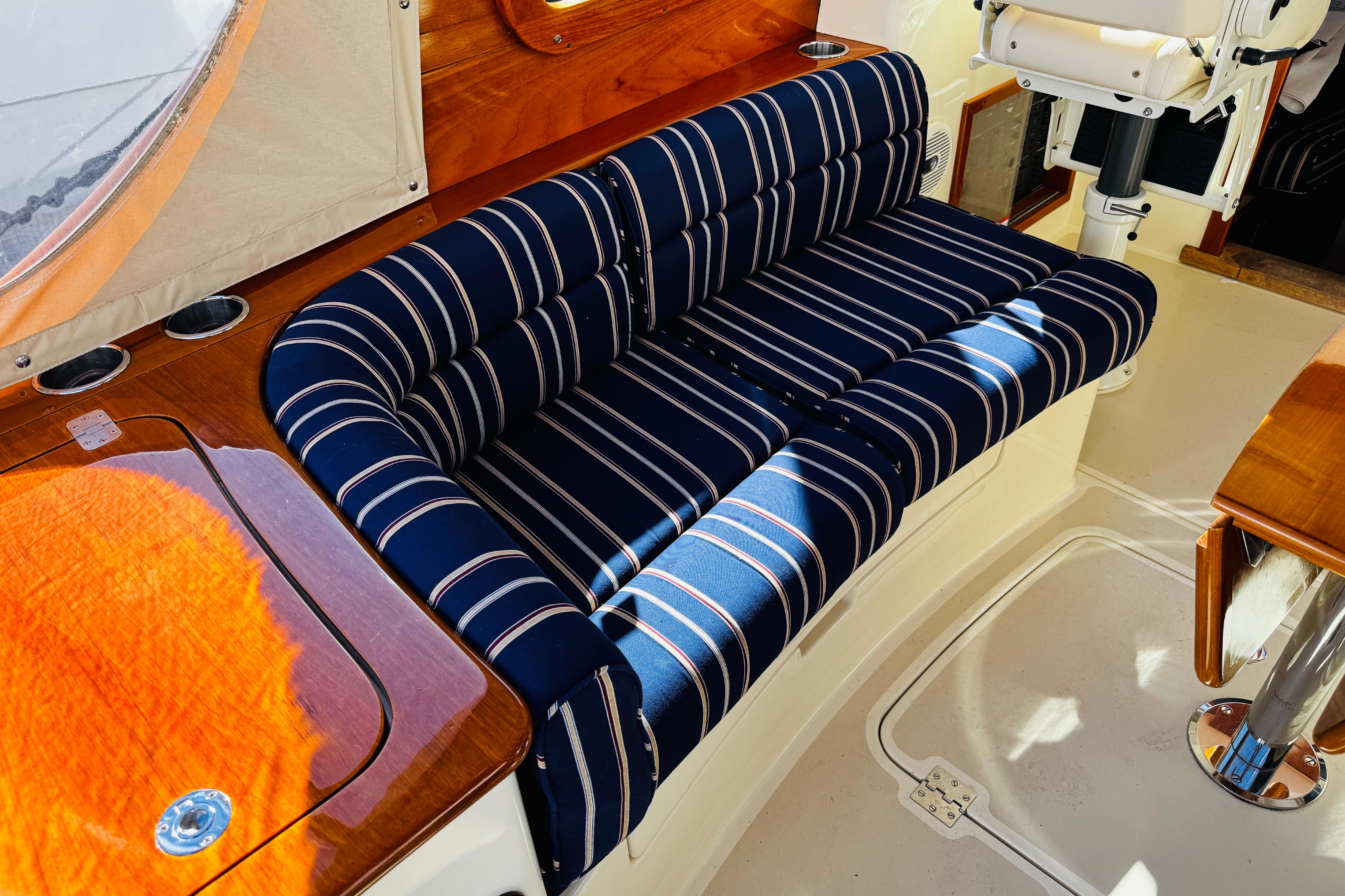 2012 Hinckley Picnic Boat MKIII interior with striped seating and wooden accents.