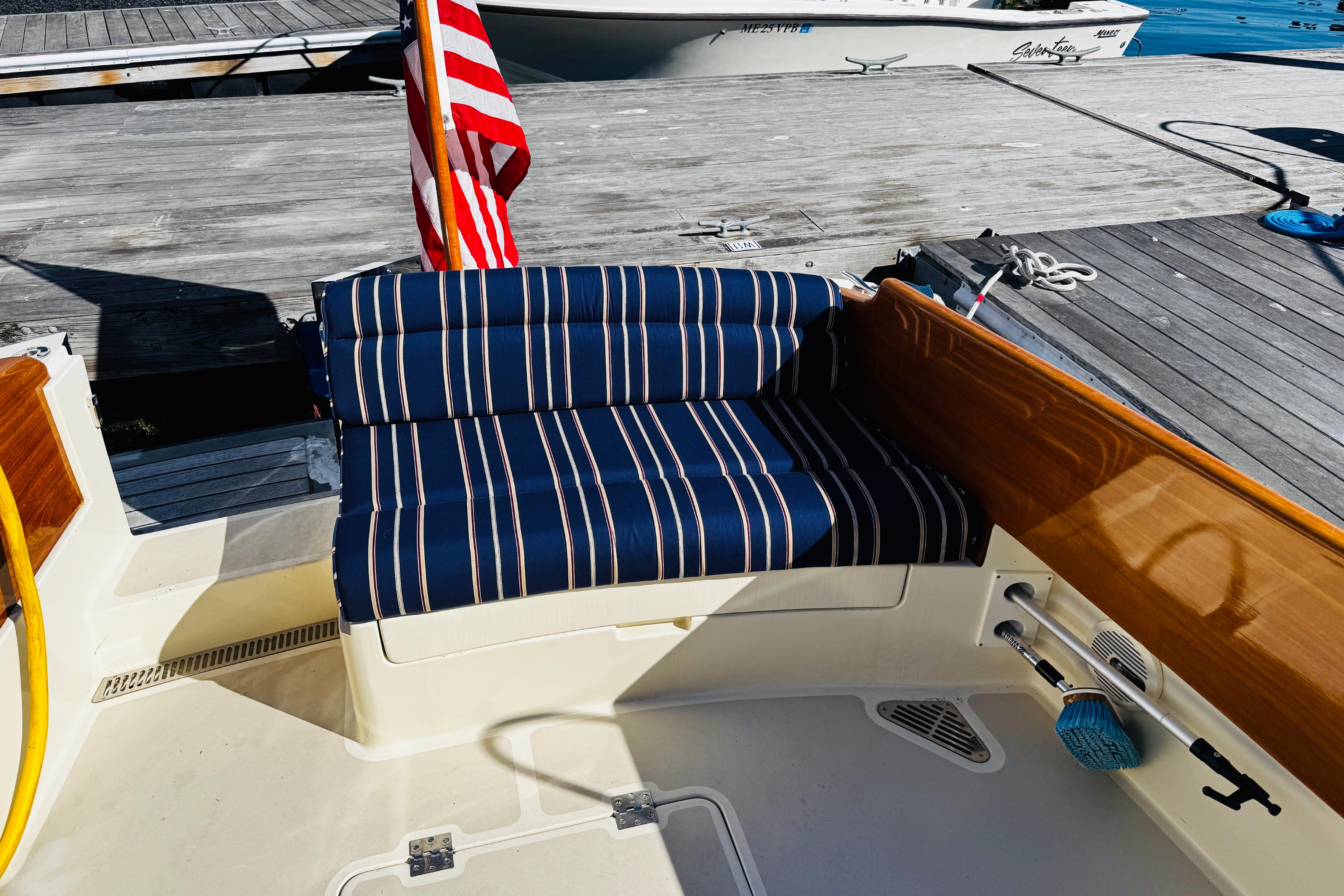 Hinckley Picnic Boat MKIII 2012 with striped seating and American flag at dock.