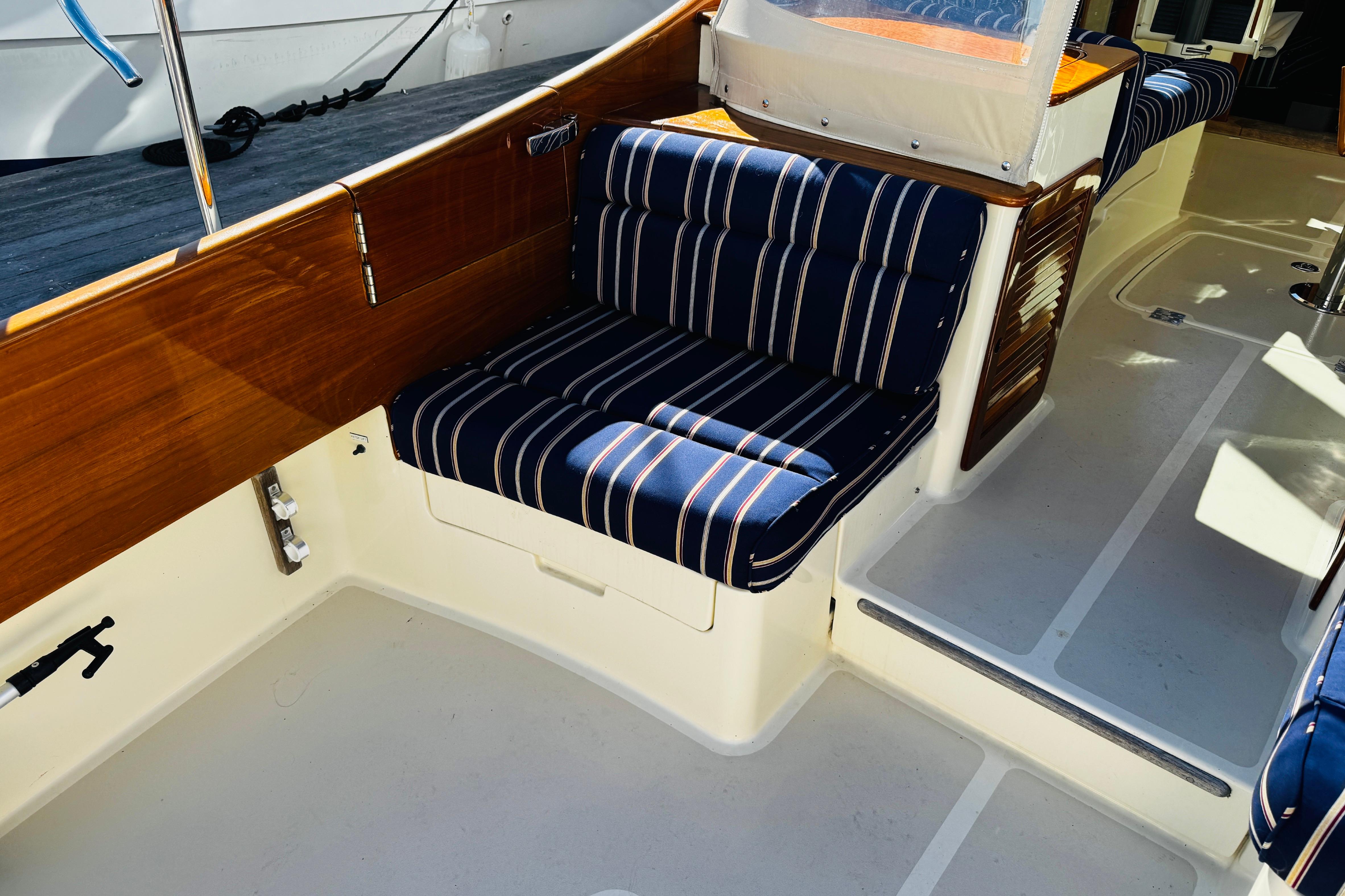 2012 Hinckley Picnic Boat MKIII interior with striped seating and wooden accents.