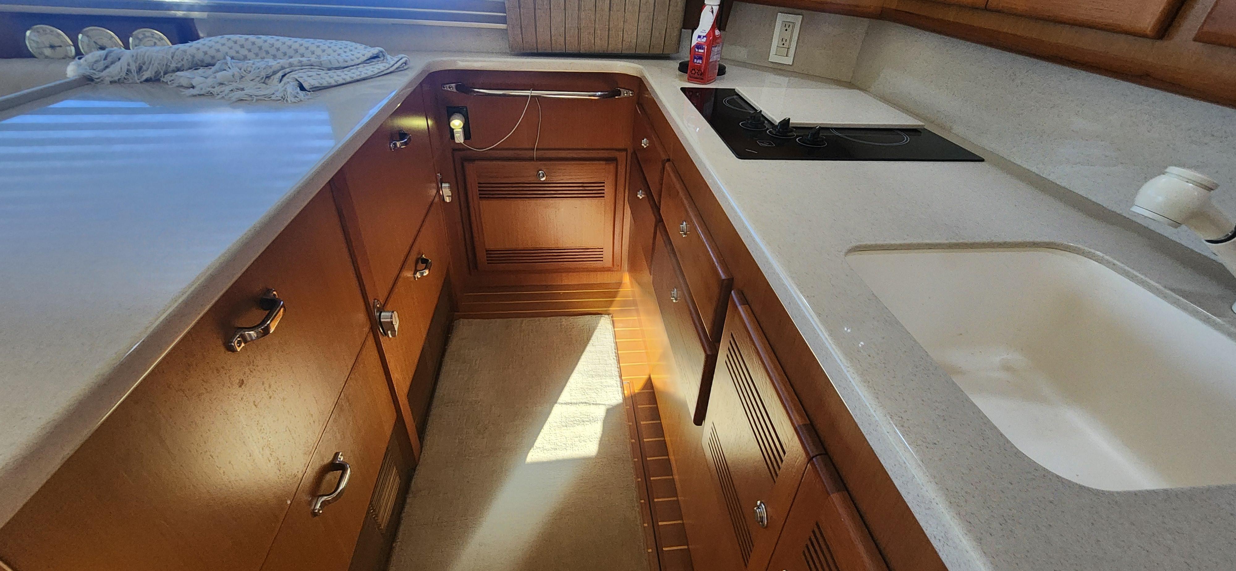 Cabo-48 Convertible 2004-Laura K AL-US-2004 Cabo 48 Convertible yacht kitchen with wooden cabinets and modern appliances.-9710440 | Thumbnail