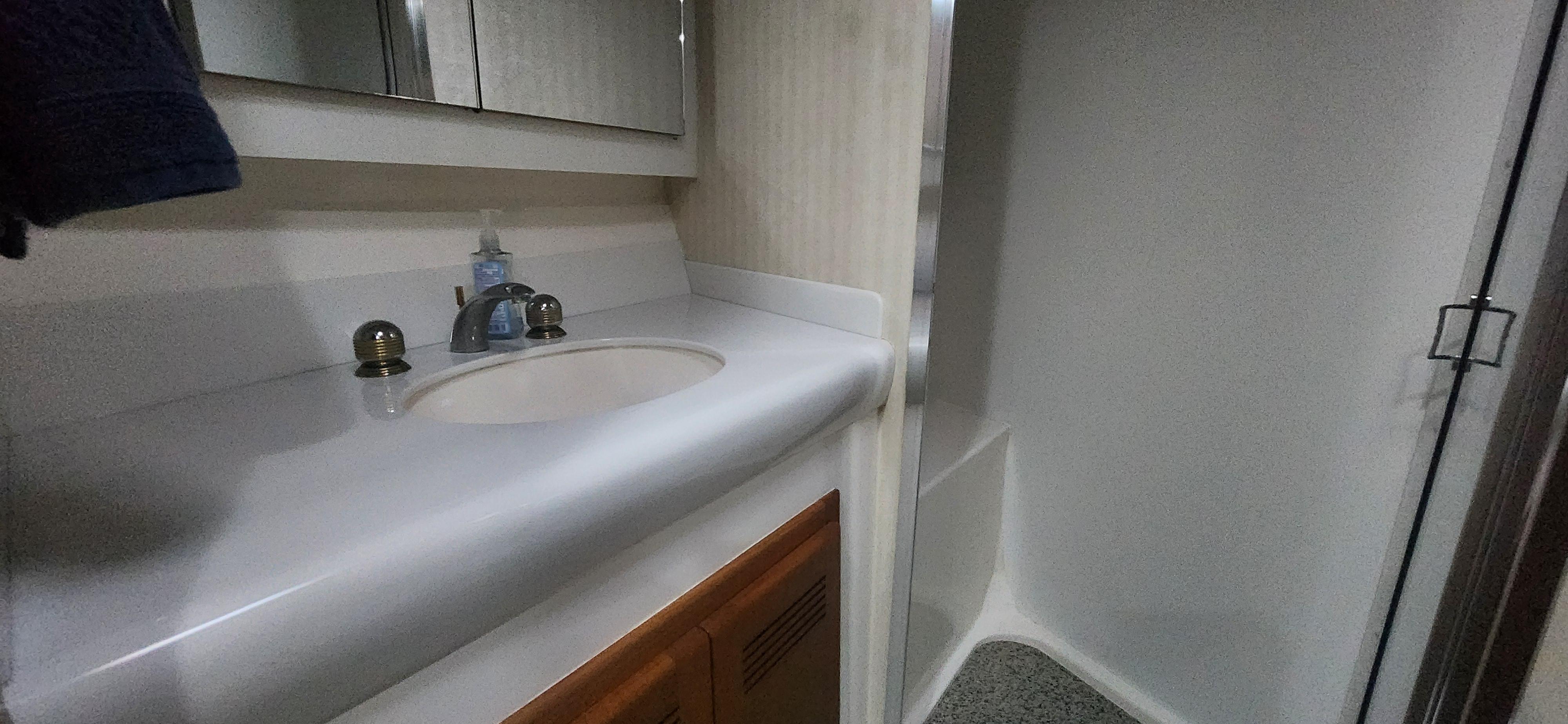 Cabo-48 Convertible 2004-Laura K AL-US-2004 Cabo 48 Convertible bathroom with sink, mirror, and shower area.-9710440 | Thumbnail