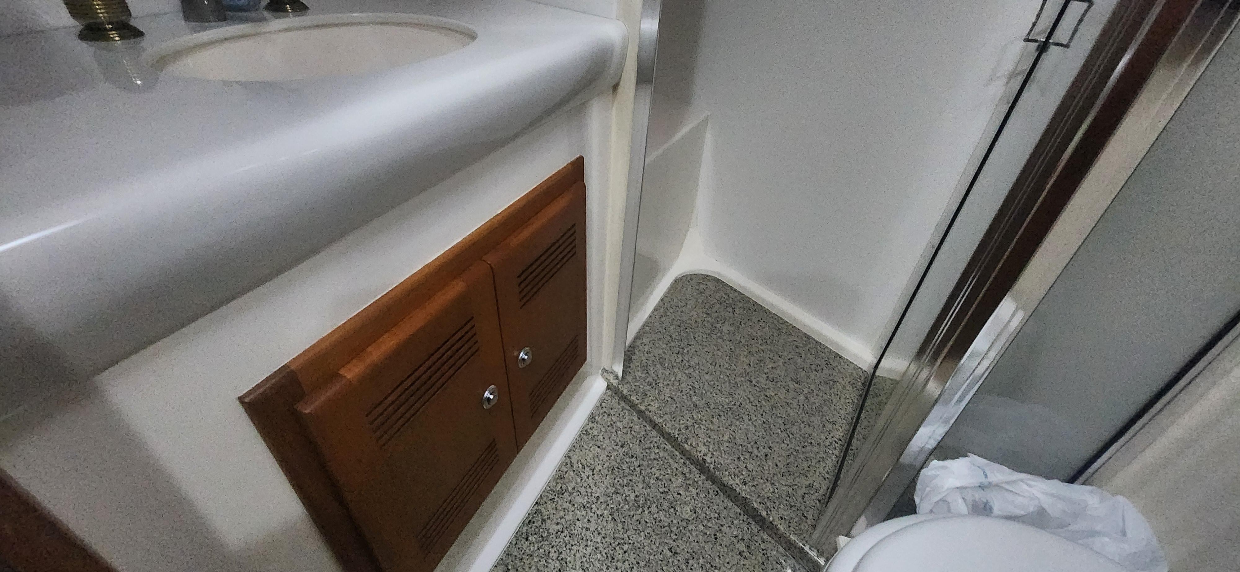 Cabo-48 Convertible 2004-Laura K AL-US-2004 Cabo 48 Convertible bathroom with sink, wooden cabinet, and shower area.-9710440 | Thumbnail