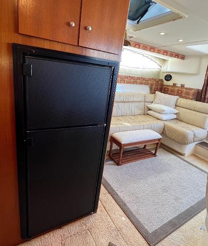 Interior of 1997 Carver 350 Mariner yacht with cozy seating and compact fridge.