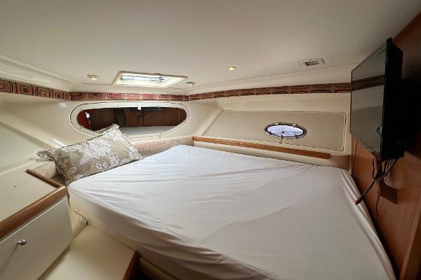 Interior of 1997 Carver 350 Mariner yacht with bed, pillows, and porthole window.