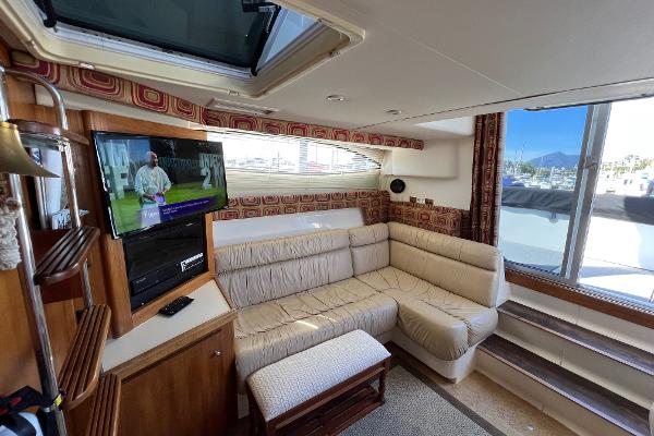 Interior of 1997 Carver 350 Mariner yacht with cozy seating and mounted TV.