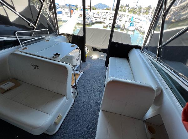 1997 Carver 350 Mariner interior with white seating, table, and marina view.