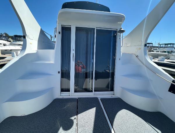 1997 Carver 350 Mariner yacht with sliding glass doors and dual staircases, docked under clear skies.