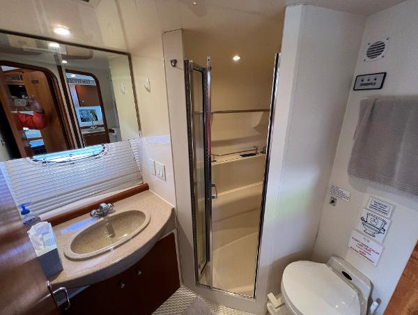 Bathroom interior of 1997 Carver 350 Mariner yacht with sink, shower, and toilet.