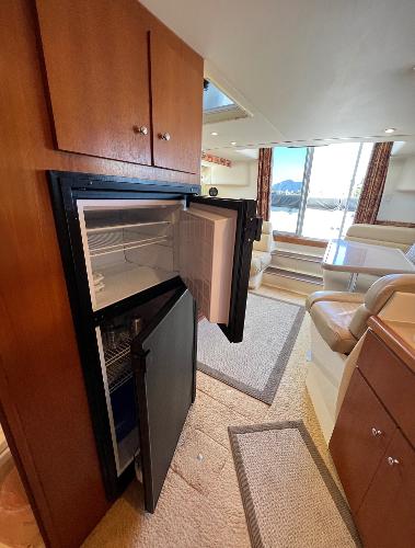 Interior of 1997 Carver 350 Mariner yacht with open fridge and seating area.