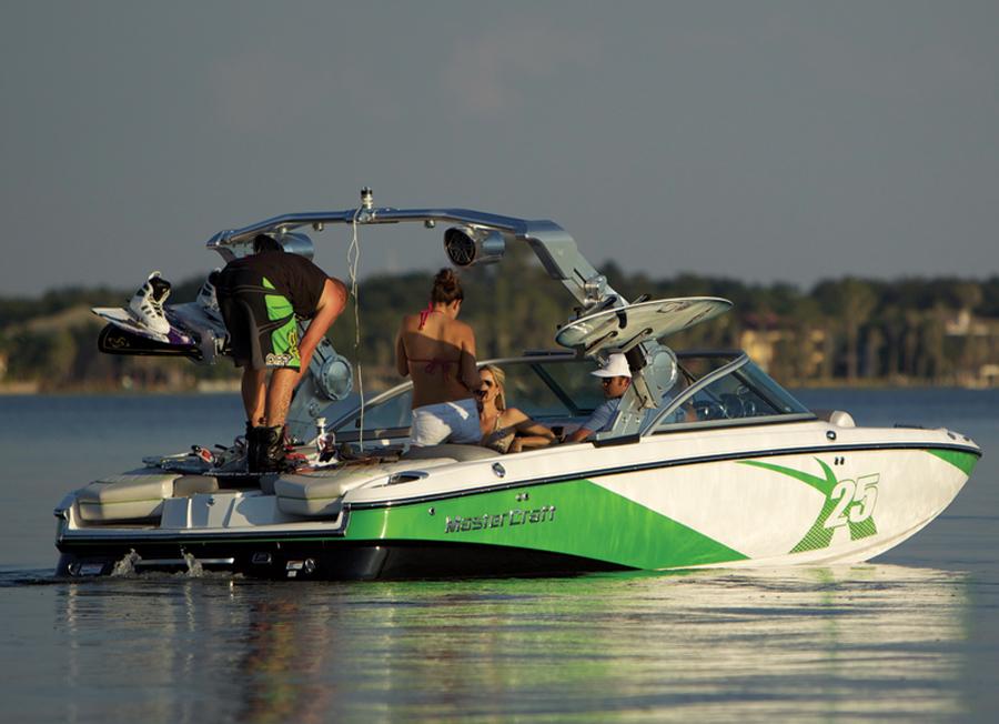 2013 MasterCraft X-25 boat on calm water, featuring people enjoying a sunny day.