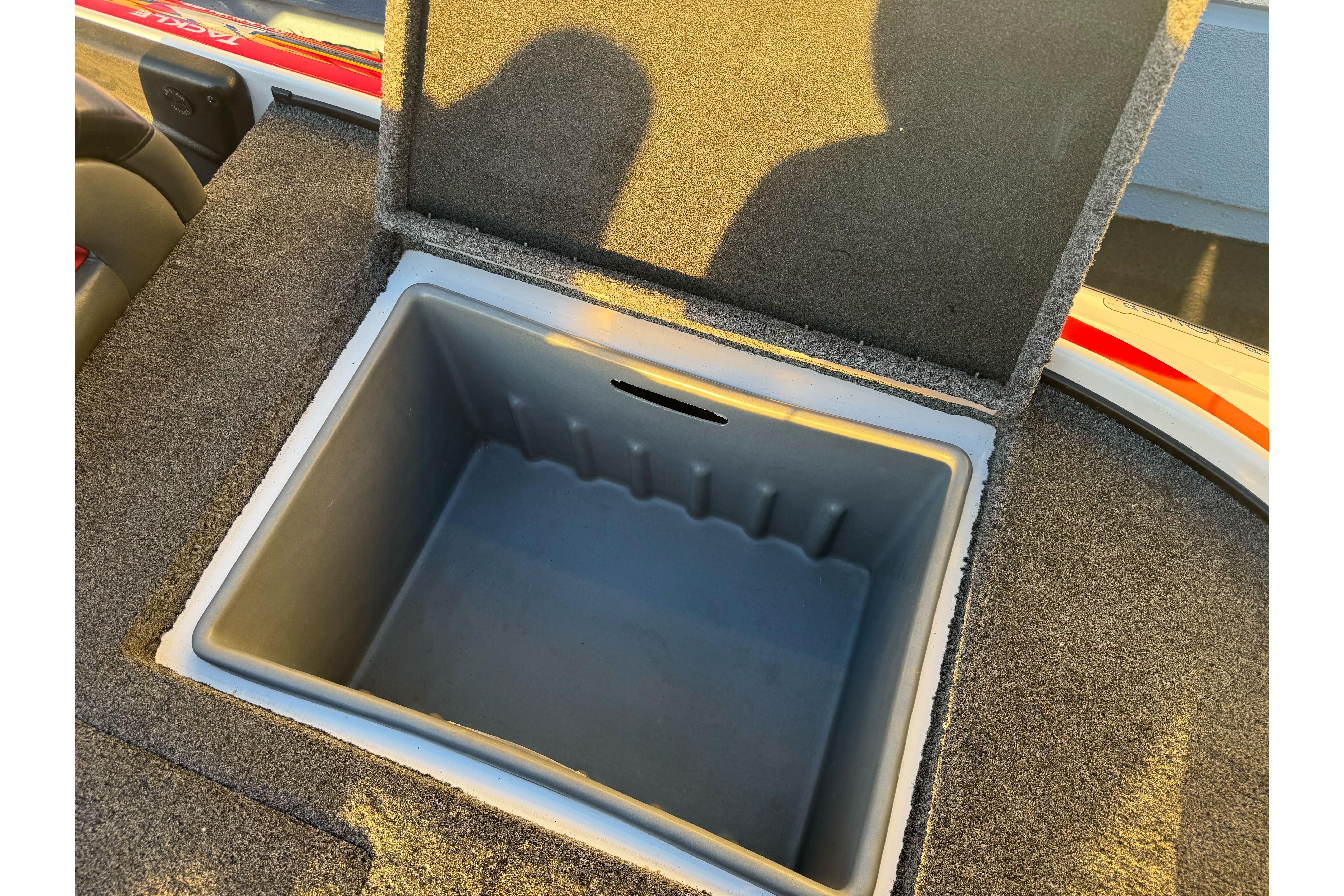 Open storage compartment in 2011 Nitro Z-9 DC boat, featuring carpeted interior.