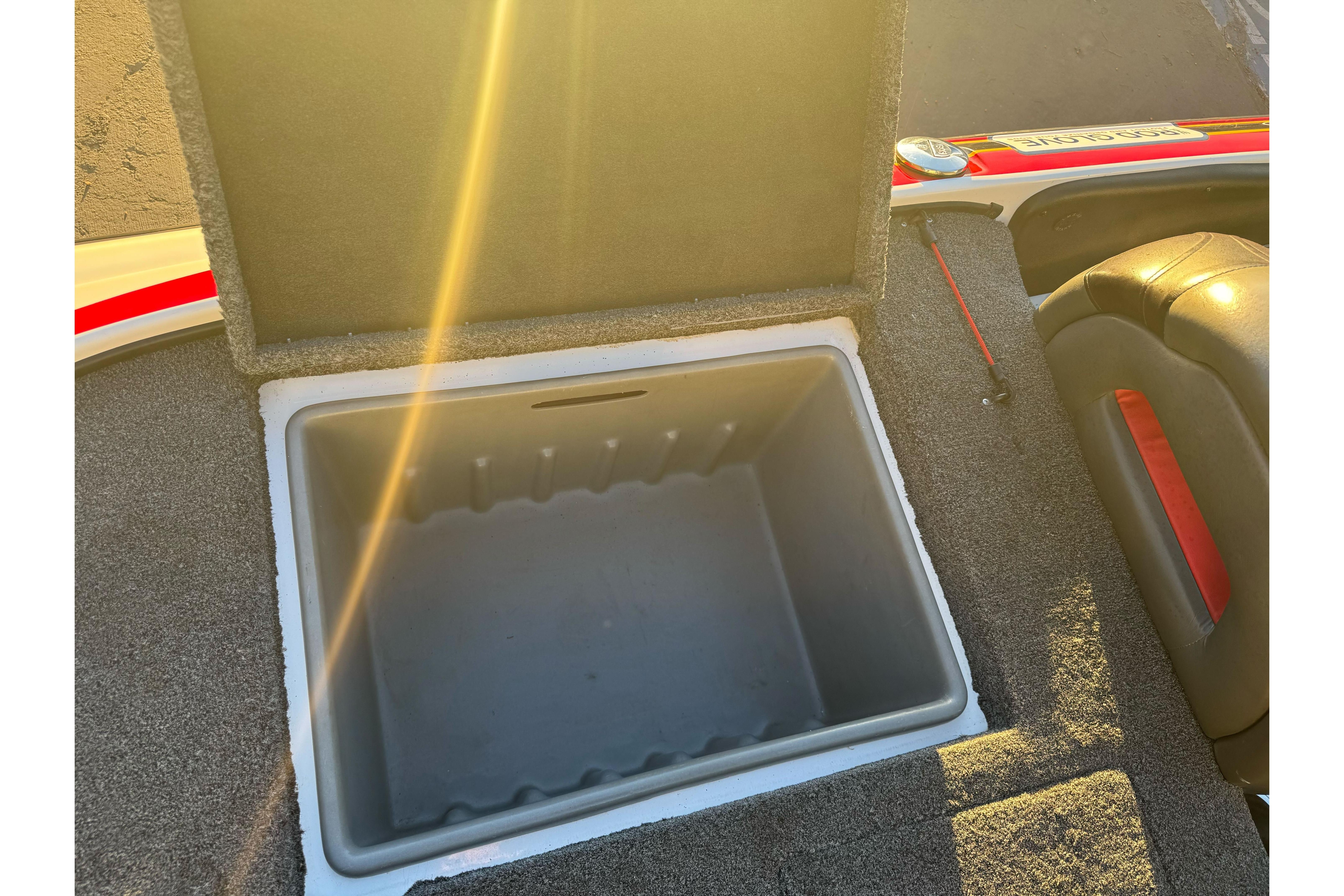 Open storage compartment on 2011 Nitro Z-9 DC boat, sunlight illuminating interior.