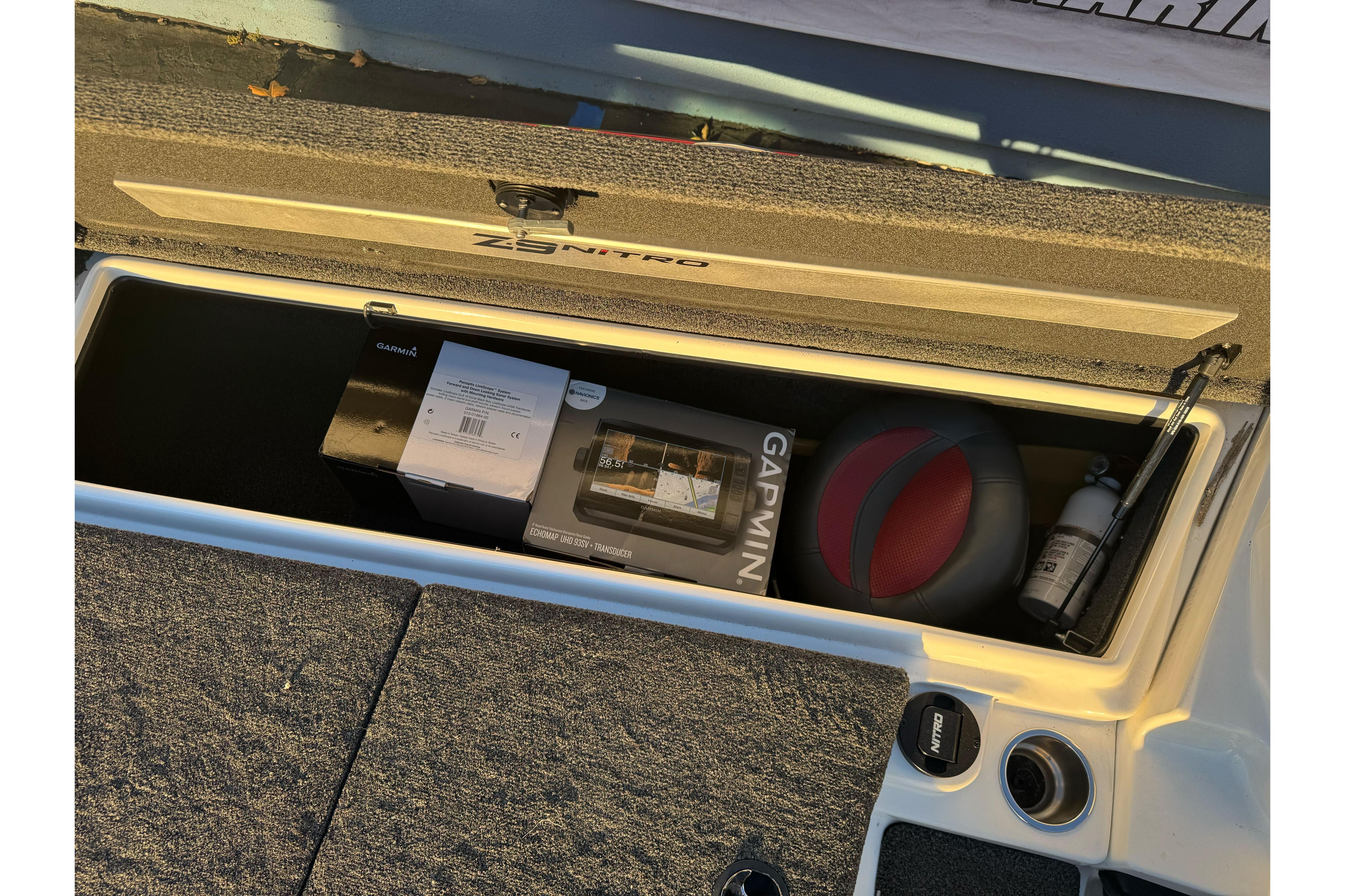 Open storage compartment in 2011 Nitro Z-9 DC boat with Garmin equipment and accessories.