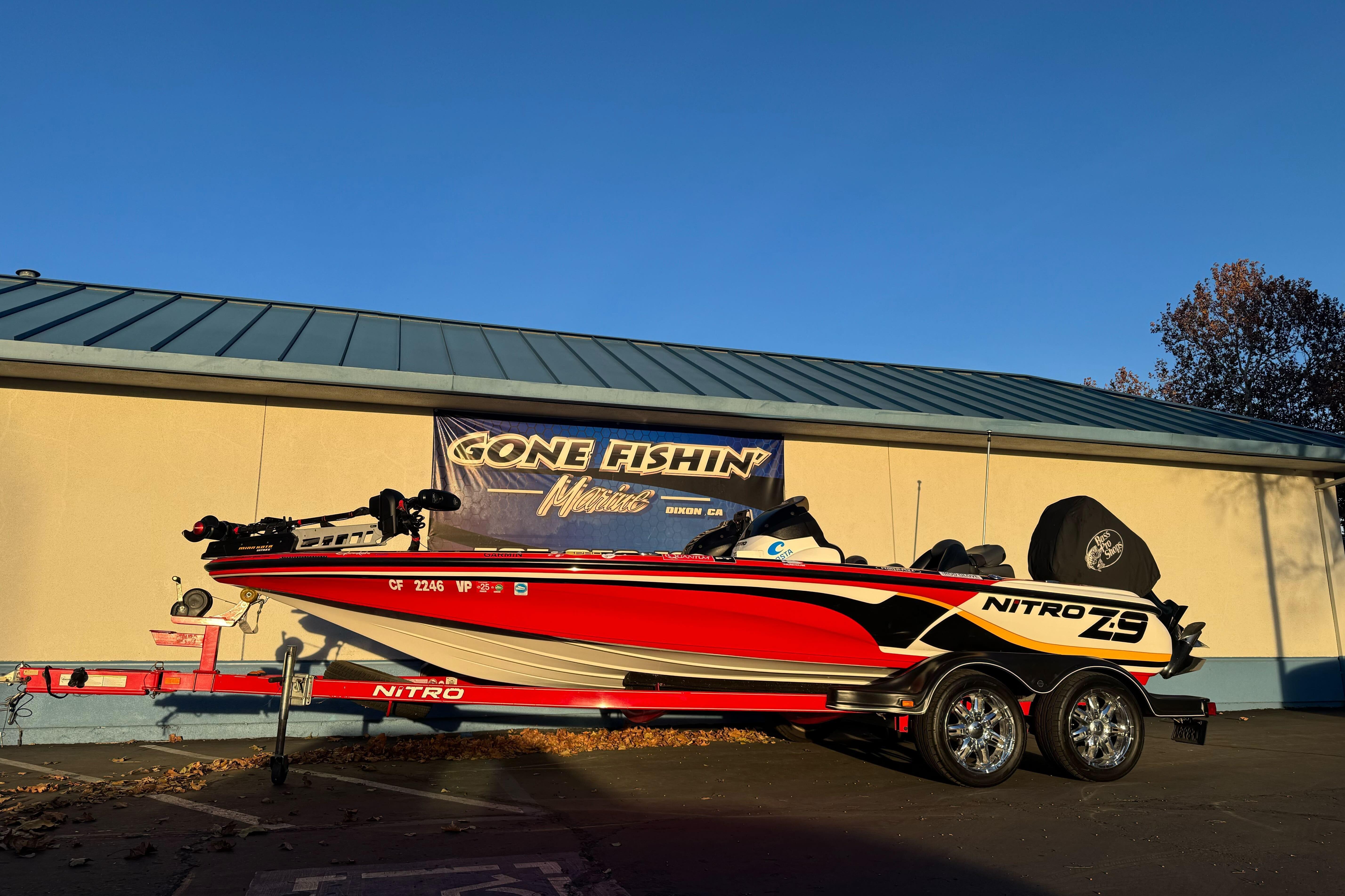 2011 Nitro Z-9 DC fishing boat on trailer, parked outside under clear blue sky.