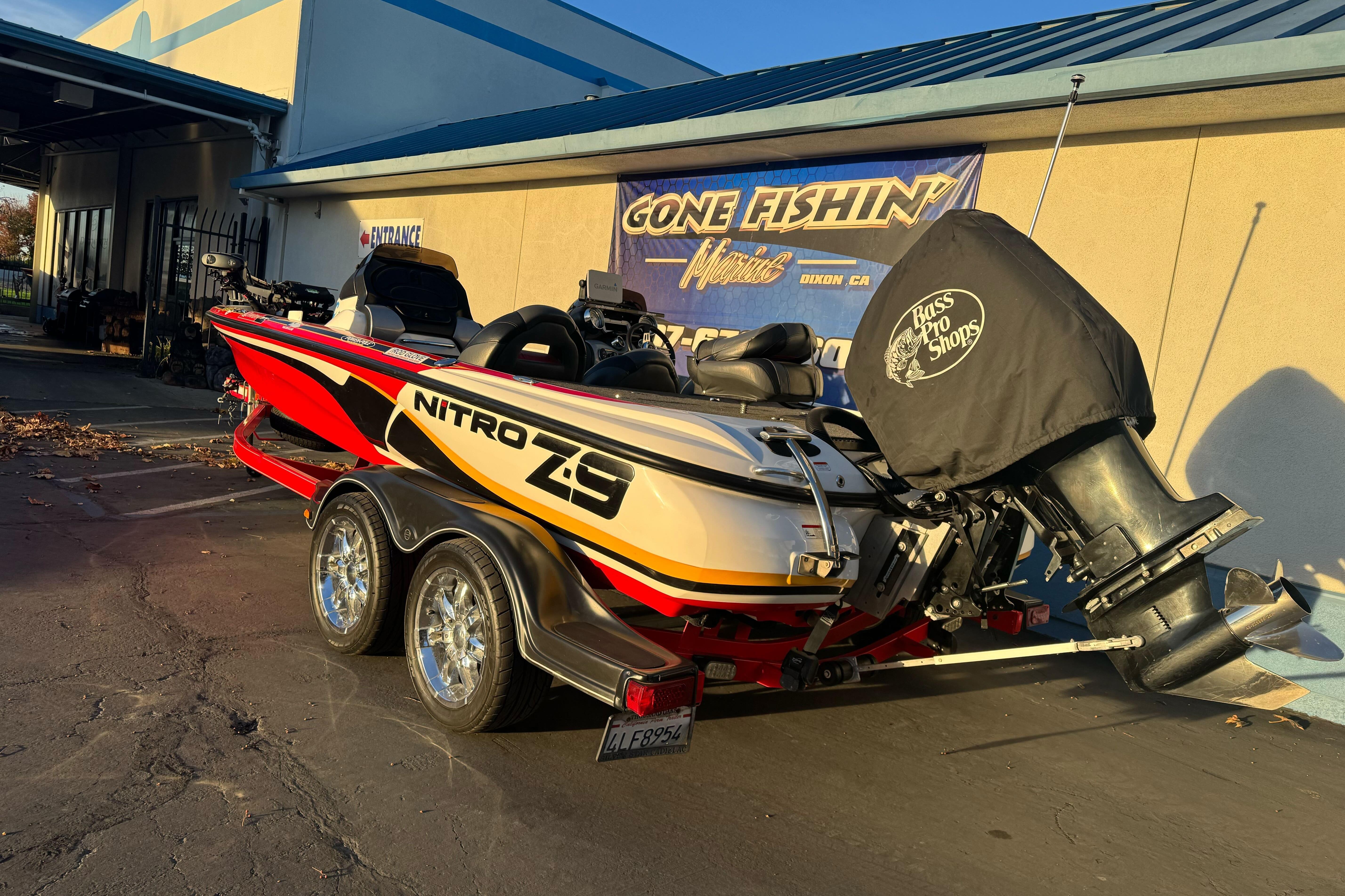 2011 Nitro Z-9 DC boat with trailer, parked outside a fishing shop.