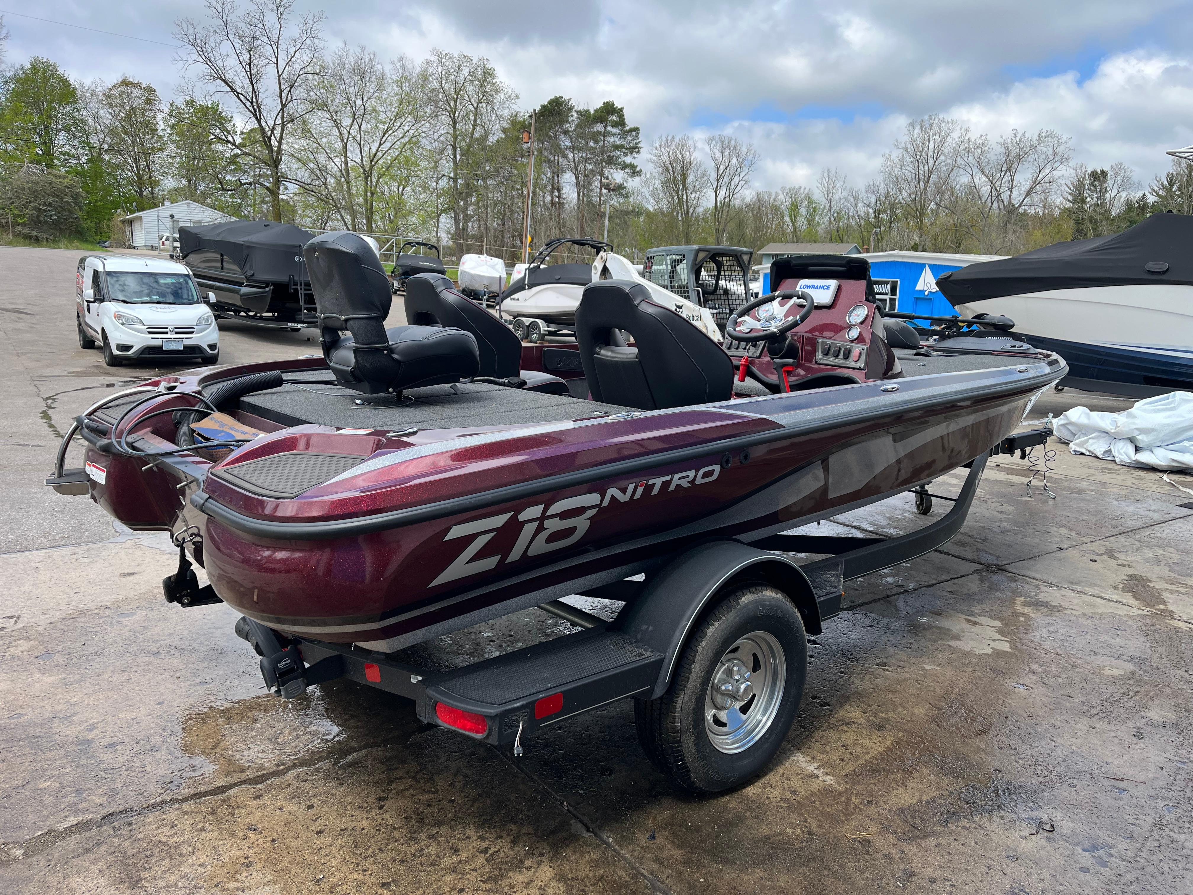 2022 Nitro Z18 boat on trailer, parked outdoors, featuring maroon color and sleek design.