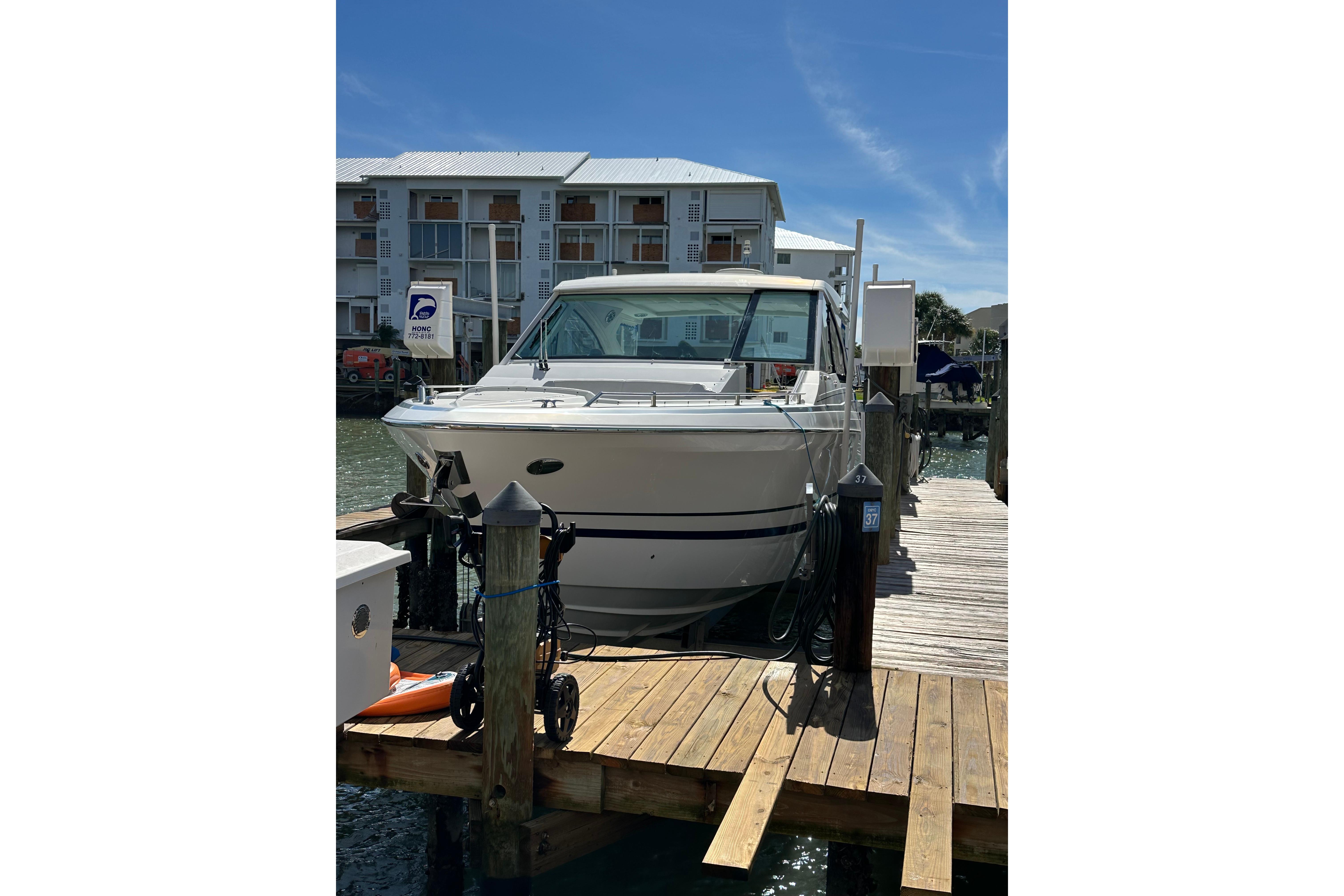 2021 Formula 380 Super Sport Crossover OB docked at marina under clear blue sky.