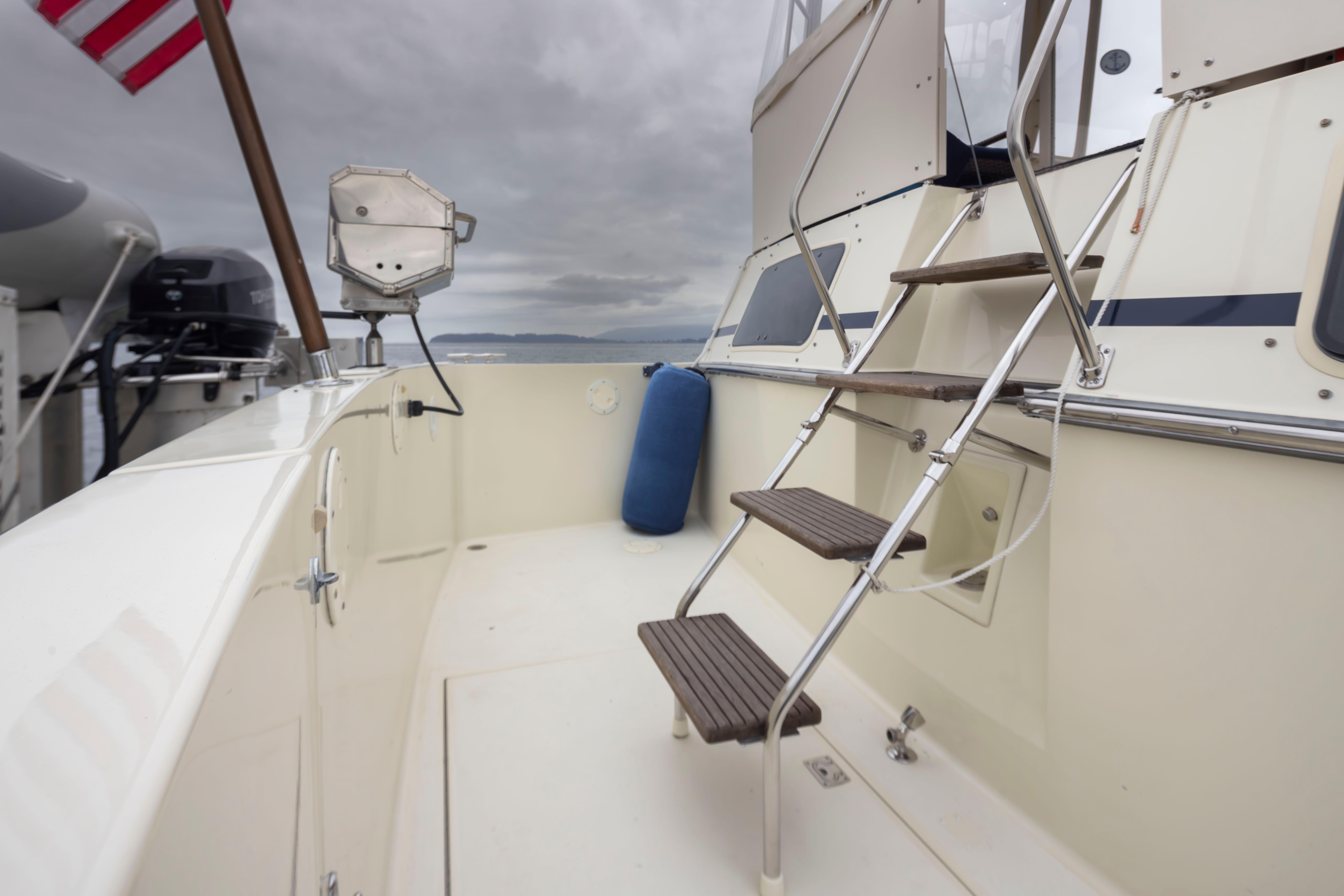 Tollycraft-44 Cockpit Motor Yacht 1990-Graceful Spirit WA-US-1990 Tollycraft 44 Cockpit Motor Yacht deck with stairs and American flag.-9844071 | Thumbnail