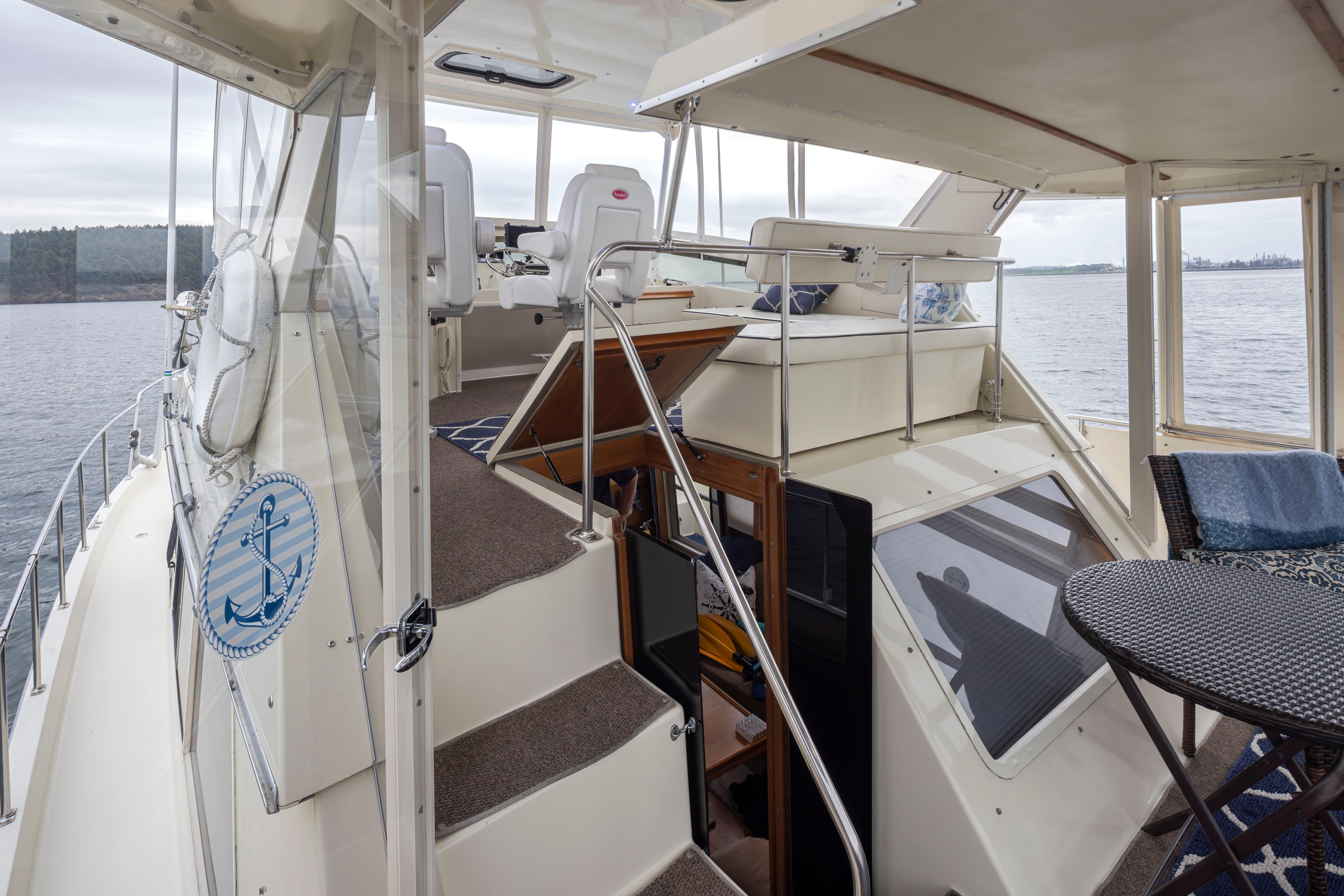 Tollycraft-44 Cockpit Motor Yacht 1990-Graceful Spirit WA-US-1990 Tollycraft 44 Cockpit Motor Yacht interior with seating and table, overlooking serene waters.-9844071 | Thumbnail