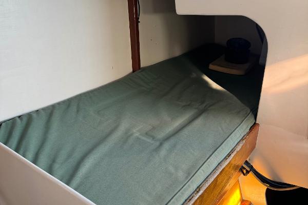 Cozy cabin interior of 1982 Greene Marine 35 Acapella sailboat with green bedding.