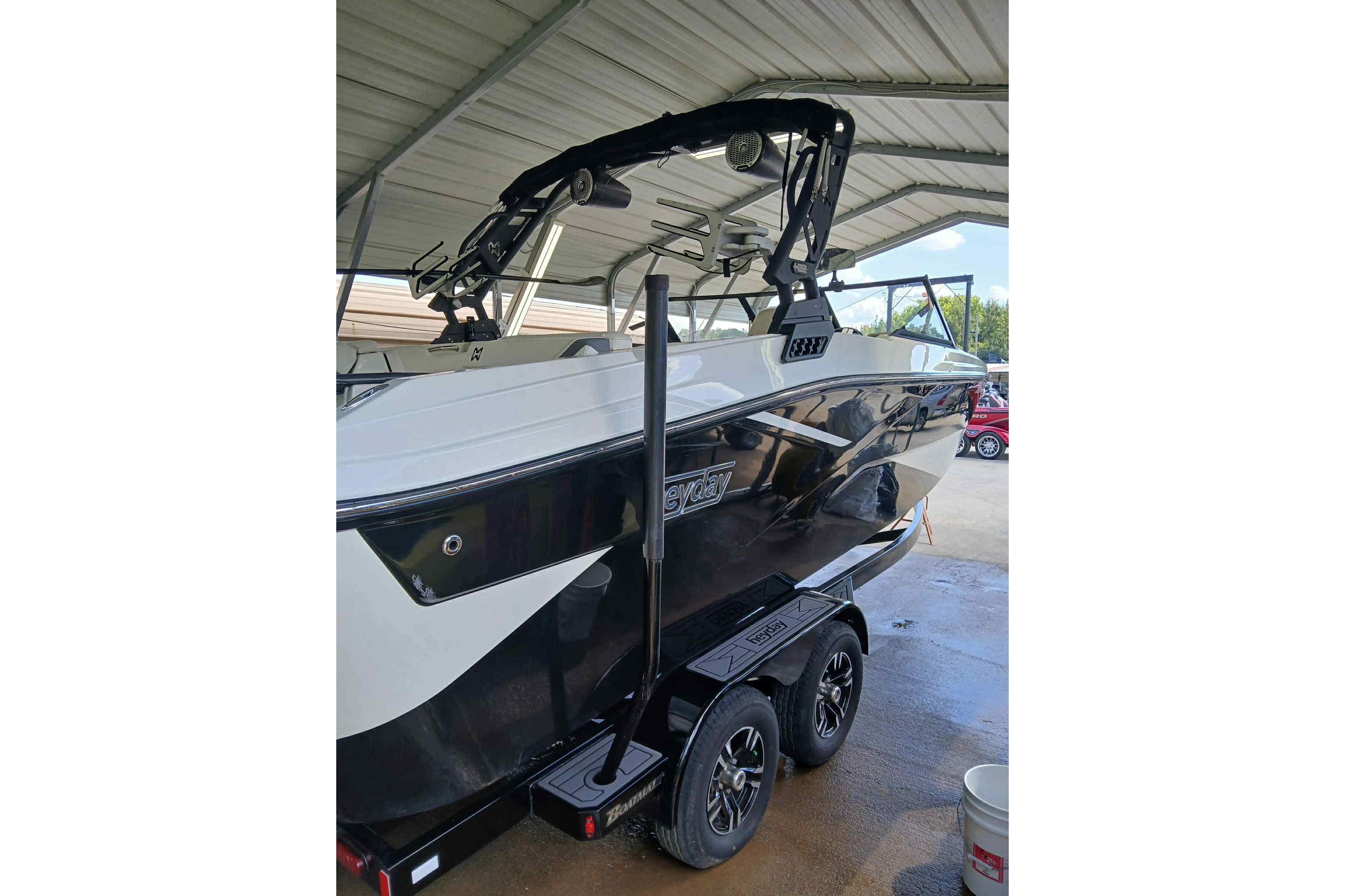 2023 Heyday H22 boat on trailer under shelter, featuring sleek black and white design.