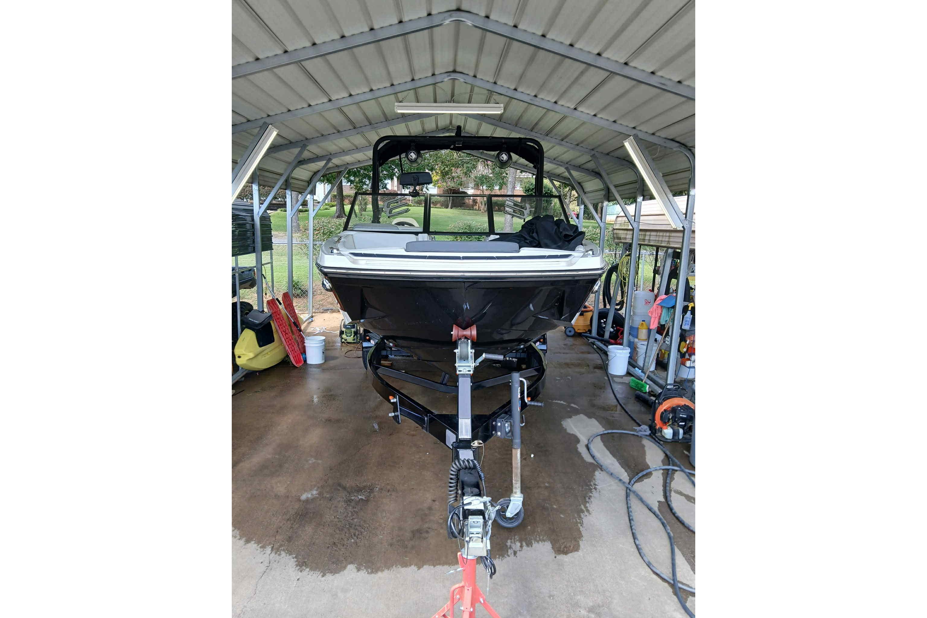 2023 Heyday H22 boat under a metal canopy, parked on a trailer.