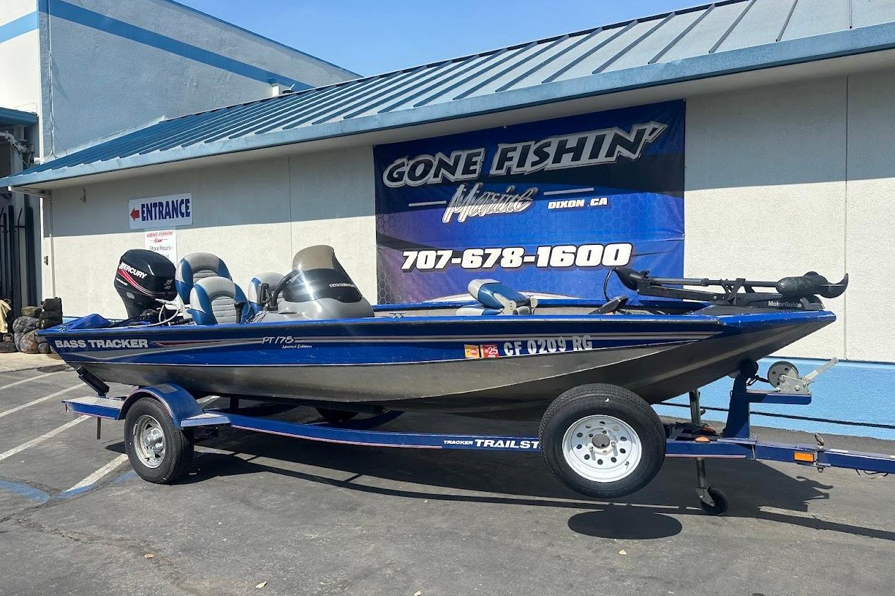 2005 Bass Tracker Pro Team 175 boat on trailer outside fishing store.