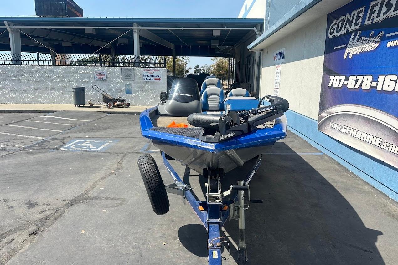 2005 Bass Tracker Pro Team 175 boat on trailer in parking lot.