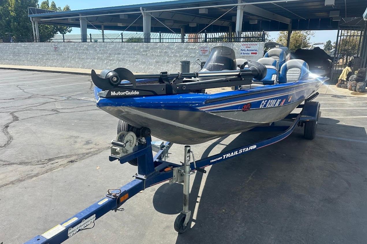 2005 Bass Tracker Pro Team 175 boat on trailer in parking lot.