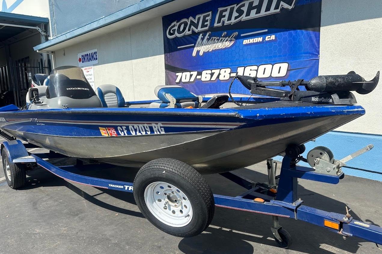 2005 Bass Tracker Pro Team 175 boat on trailer, parked outside a marine shop.