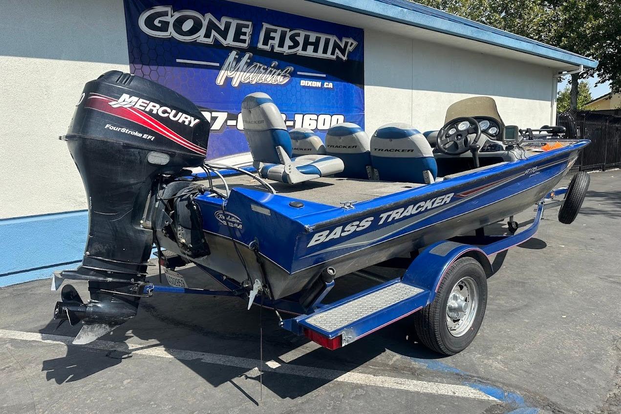 2005 Bass Tracker Pro Team 175 boat with Mercury FourStroke EFI engine, parked outside dealership.